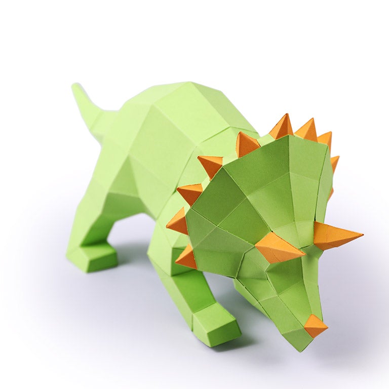 A vibrant green Triceratops 3D paper model lamp with orange horn spikes, showcasing intricate details and a unique design.