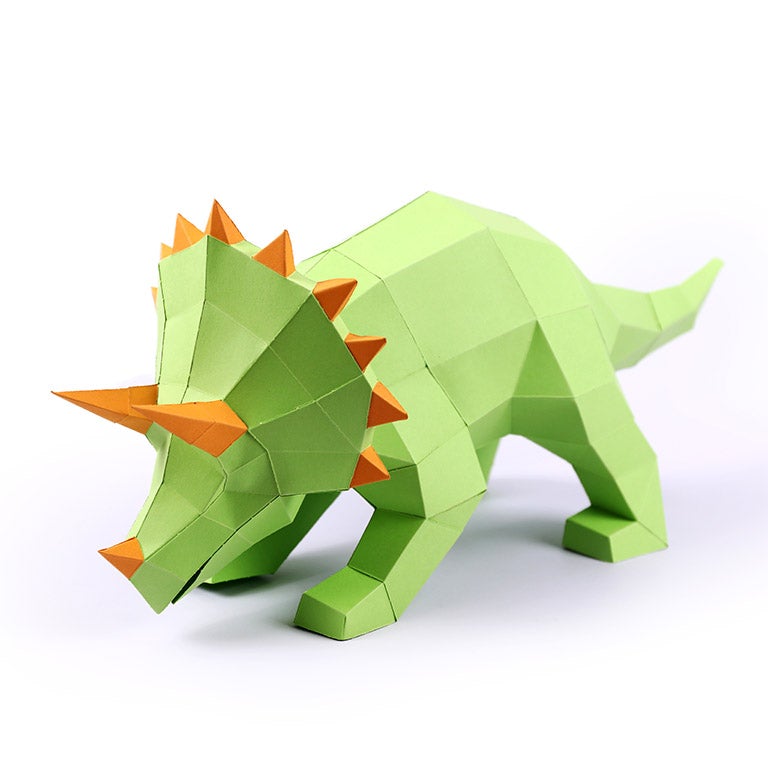 A vibrant green Triceratops 3D paper model lamp with orange horn spikes, showcasing intricate details and a unique design.