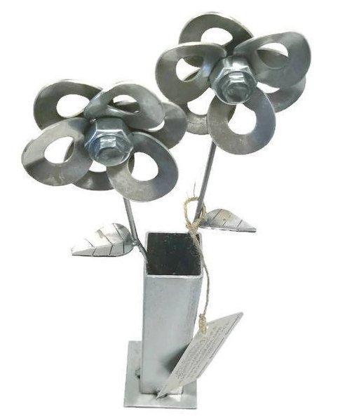 Two handcrafted metal flowers made from recycled materials, displayed in a steel vase, showcasing unique welded art.