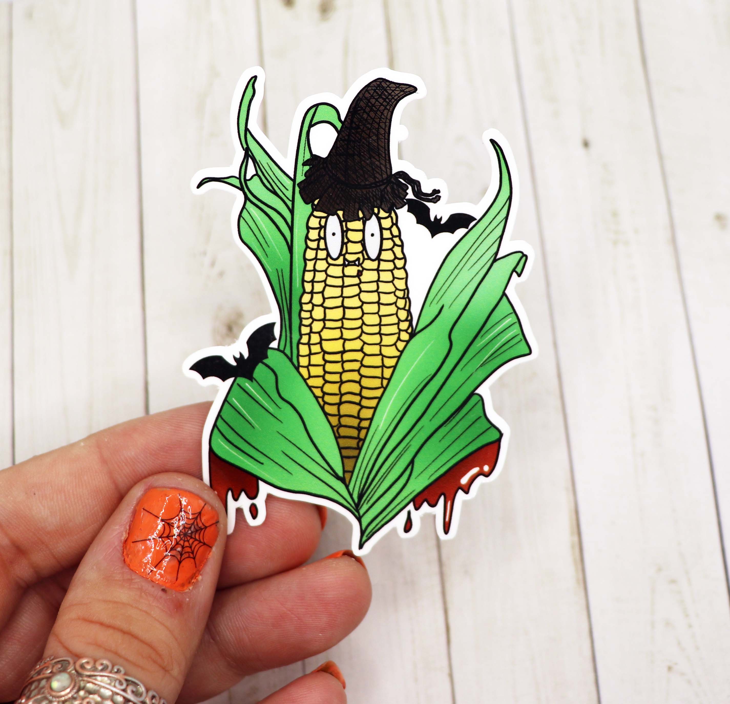 A vibrant Vampire Corn Vinyl Sticker featuring a playful corn character with vampire fangs, perfect for personalizing various items.