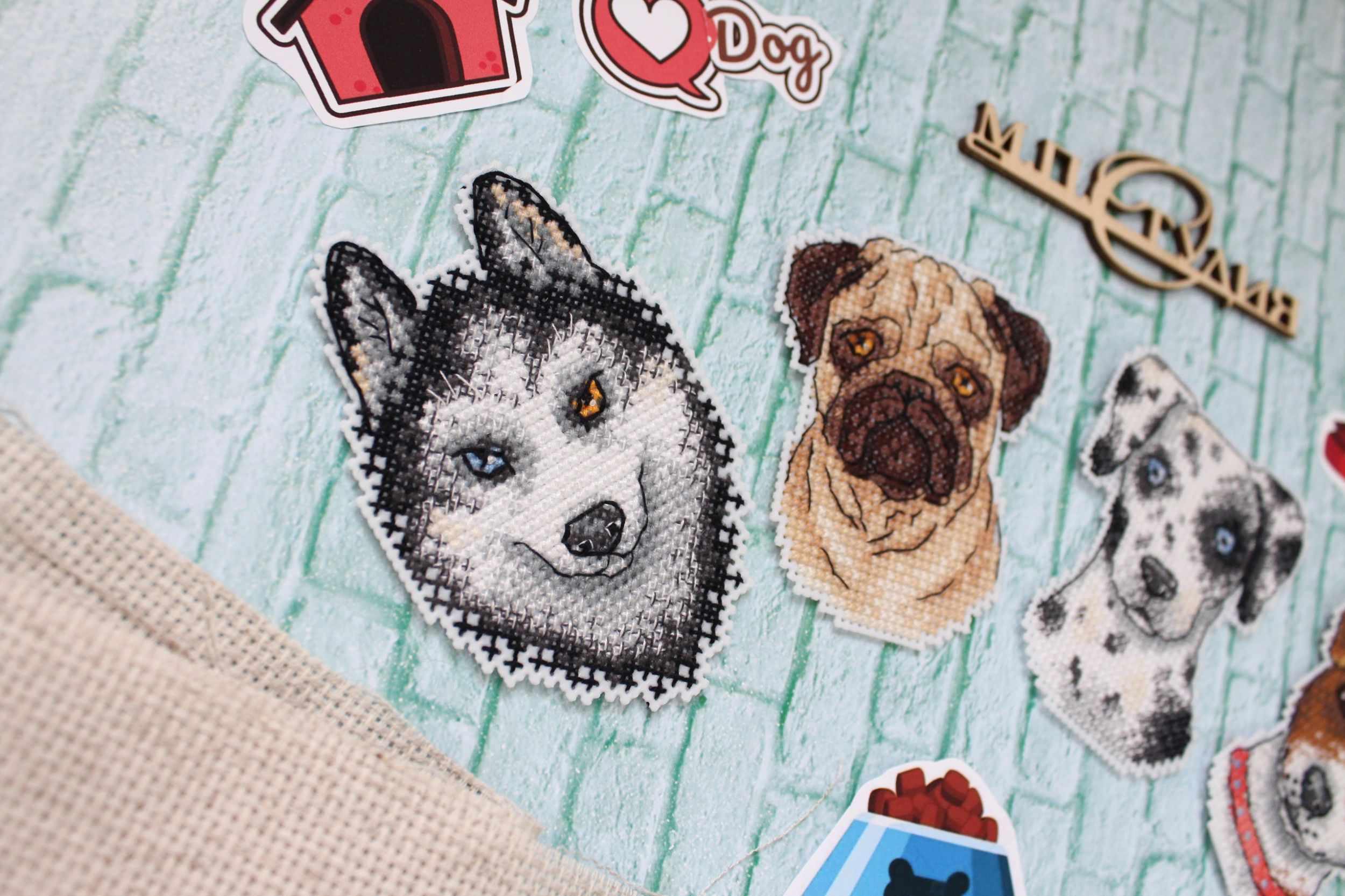 Who Said Woof? Magnets SR-409 Cross Stitch Kit featuring colorful threads, plastic canvas, and finished dog-themed magnets.