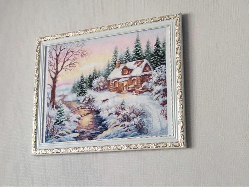 Counted cross-stitch kit featuring a winter scene with white aida fabric and colorful threads.