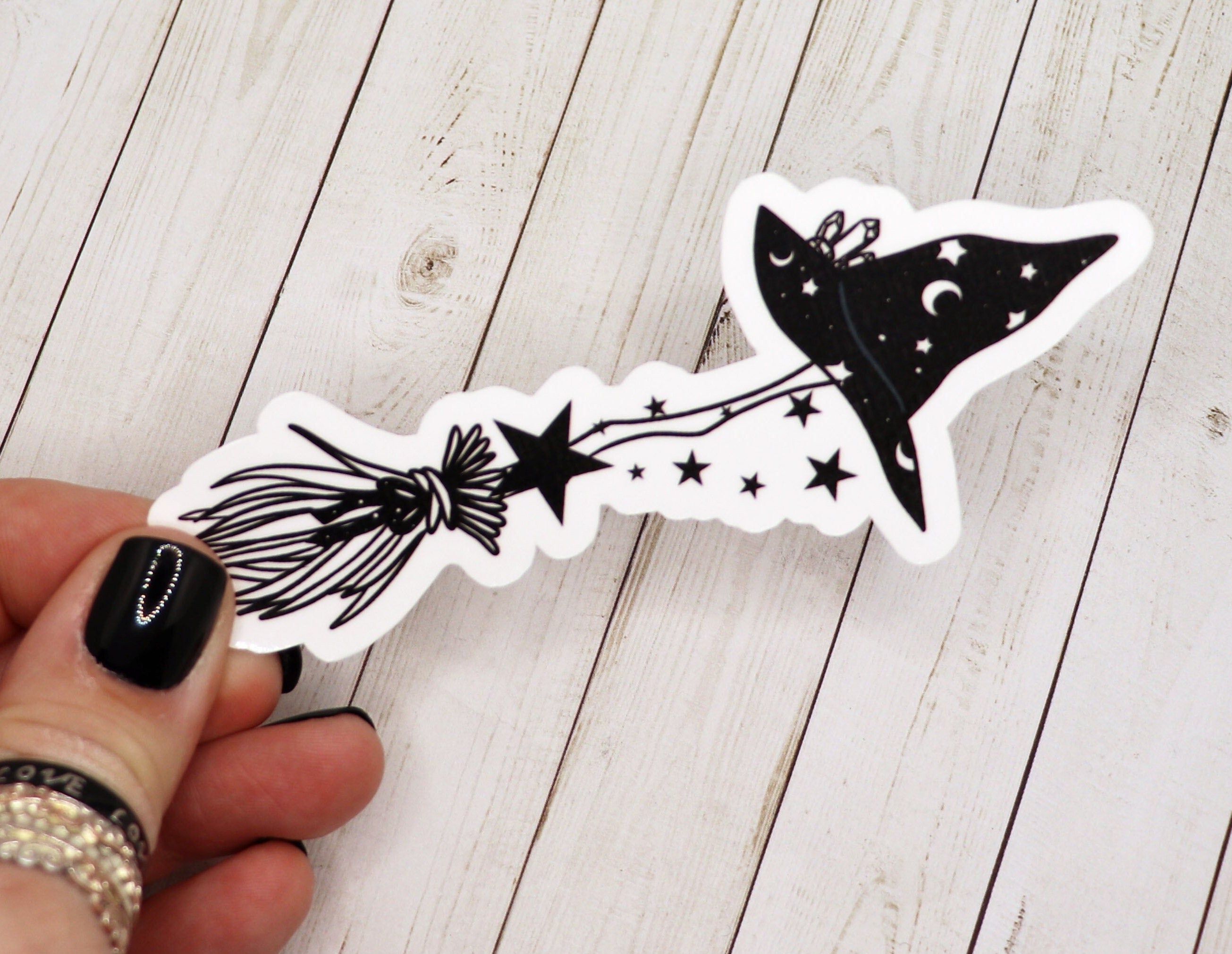 A vibrant Witch Broom Sticker on a matte vinyl surface, showcasing intricate details and a whimsical design.