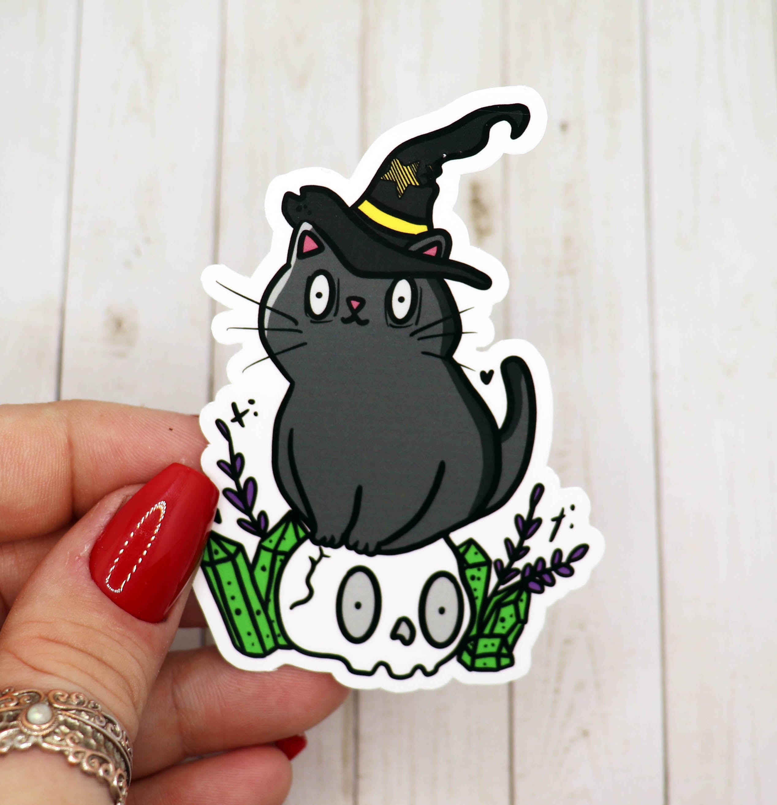 A whimsical Witchy Black Cat Vinyl Sticker featuring a black cat with mystical elements, perfect for personalizing items.