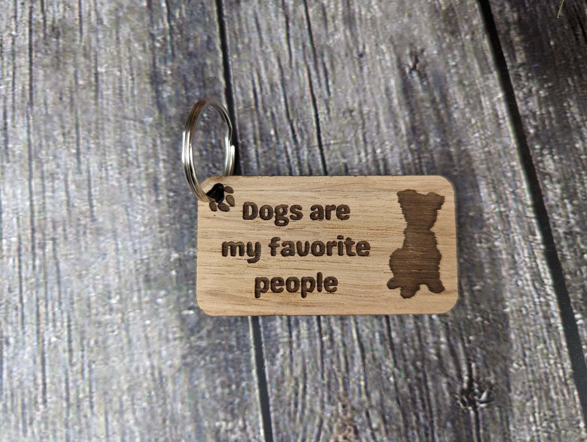 Eco-friendly wooden keyring with engraved message 'Dogs Are My Favourite People', crafted from sustainable wood.