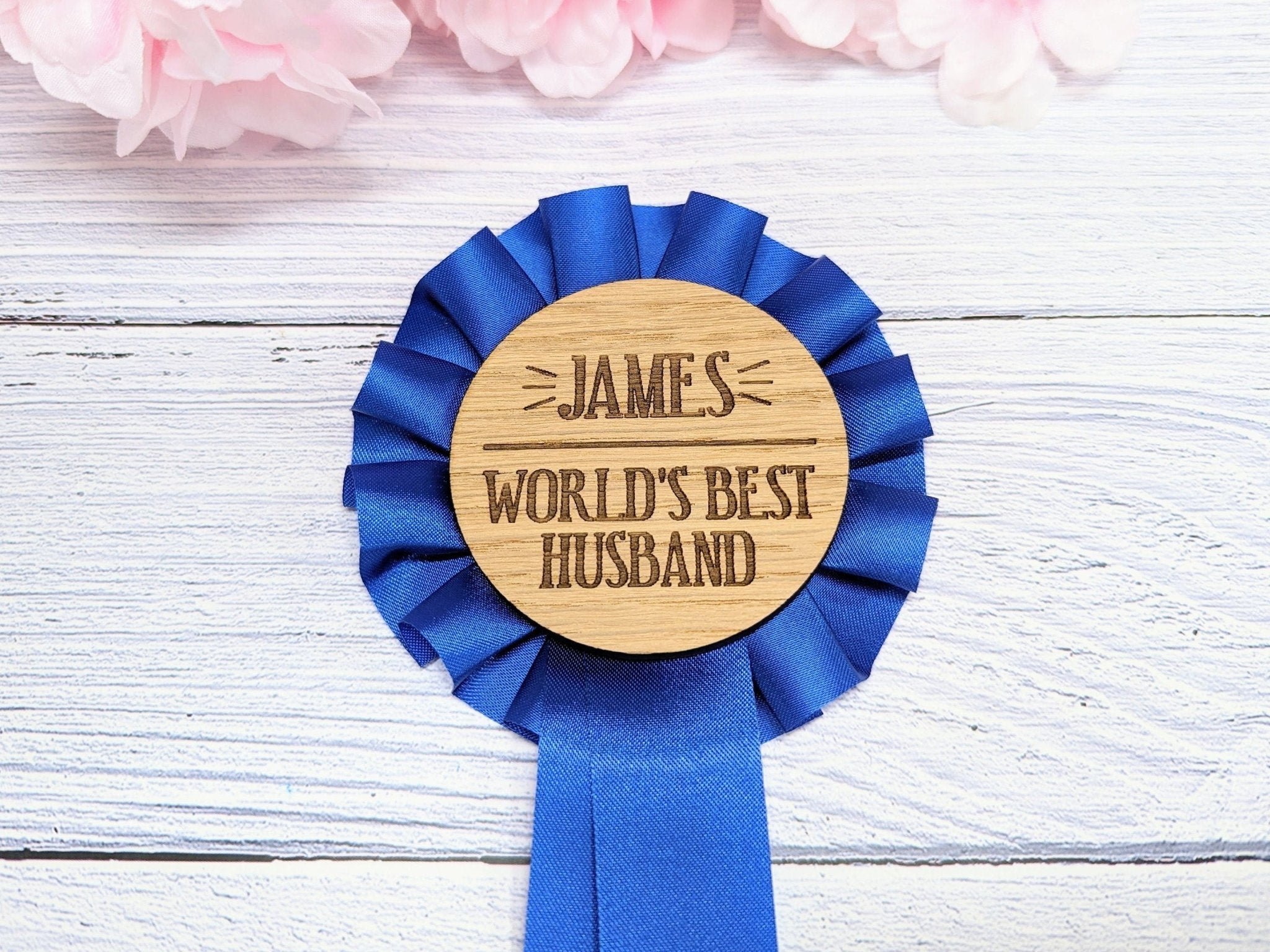 Personalised wooden rosette with blue award ribbon, featuring 'World's Best Husband' text, handcrafted from oak veneered MDF.