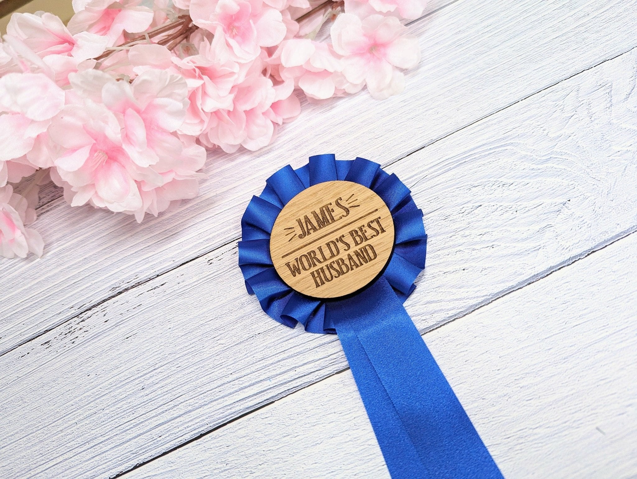 Personalised wooden rosette with blue award ribbon, featuring 'World's Best Husband' text, handcrafted from oak veneered MDF.