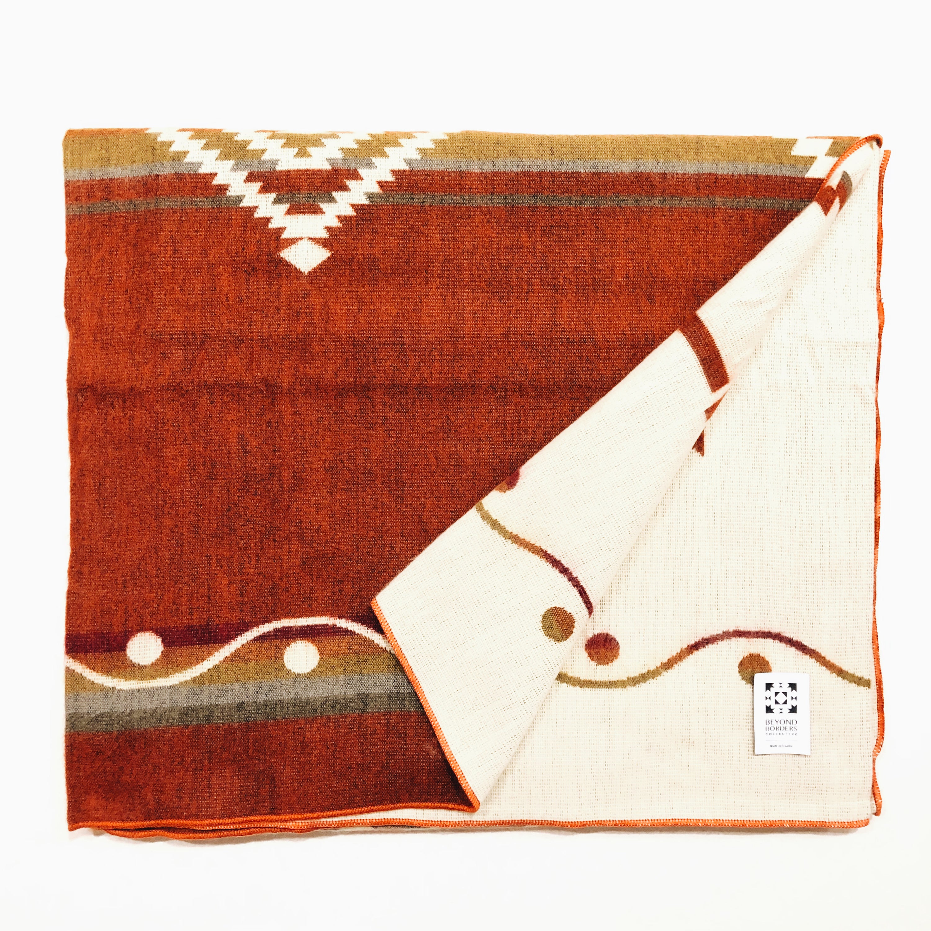 Achuar Blanket - Autumn, a vibrant and cozy blanket handcrafted by indigenous artisans from Ecuador, featuring reversible colors and soft texture.