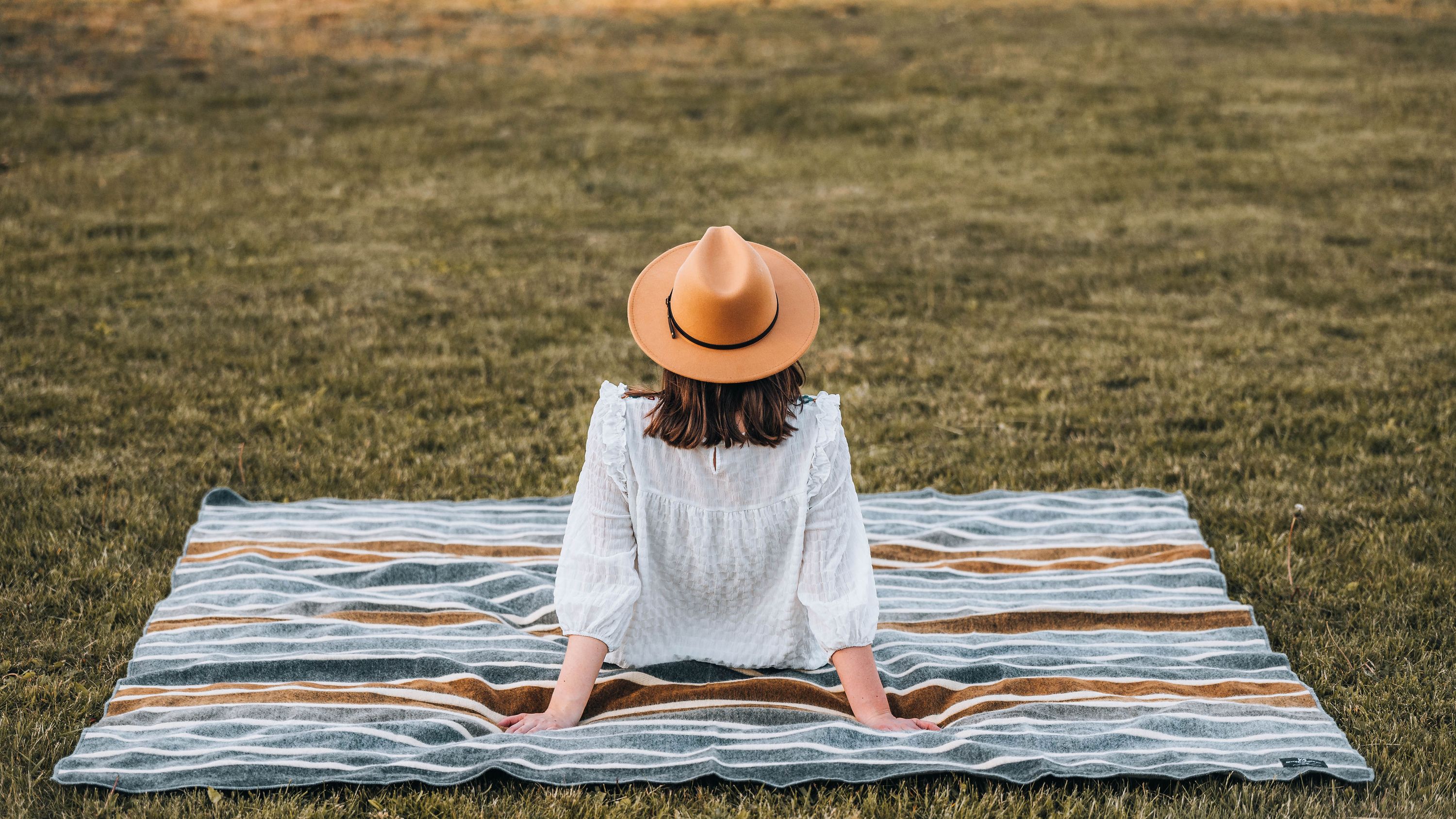 Caminante Blanket - Earth, a queen-sized, reversible blanket made from 100% recycled acrylic, showcasing a minimalist design inspired by Ecuadorian culture.