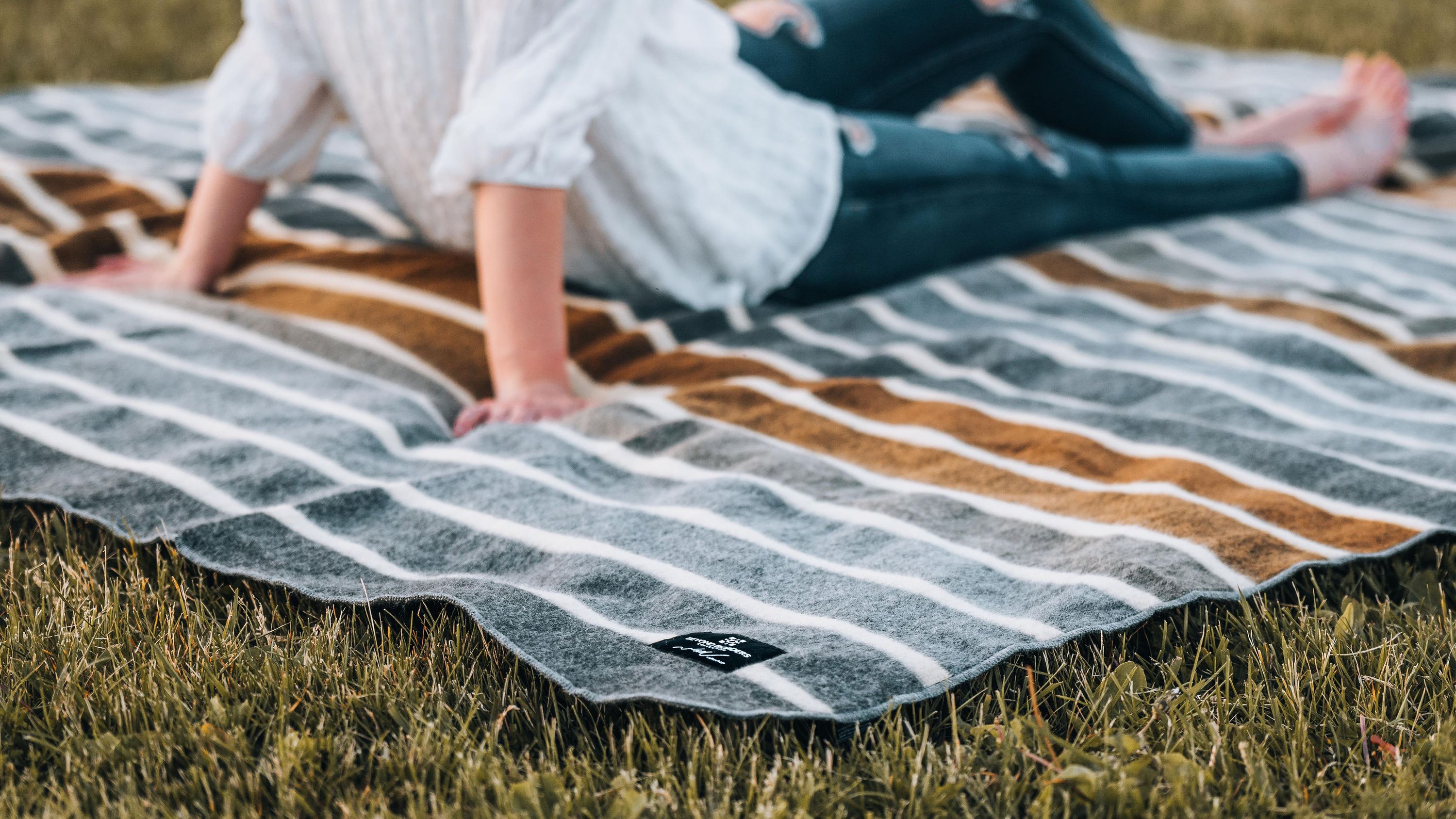 Caminante Blanket - Earth, a queen-sized, reversible blanket made from 100% recycled acrylic, showcasing a minimalist design inspired by Ecuadorian culture.