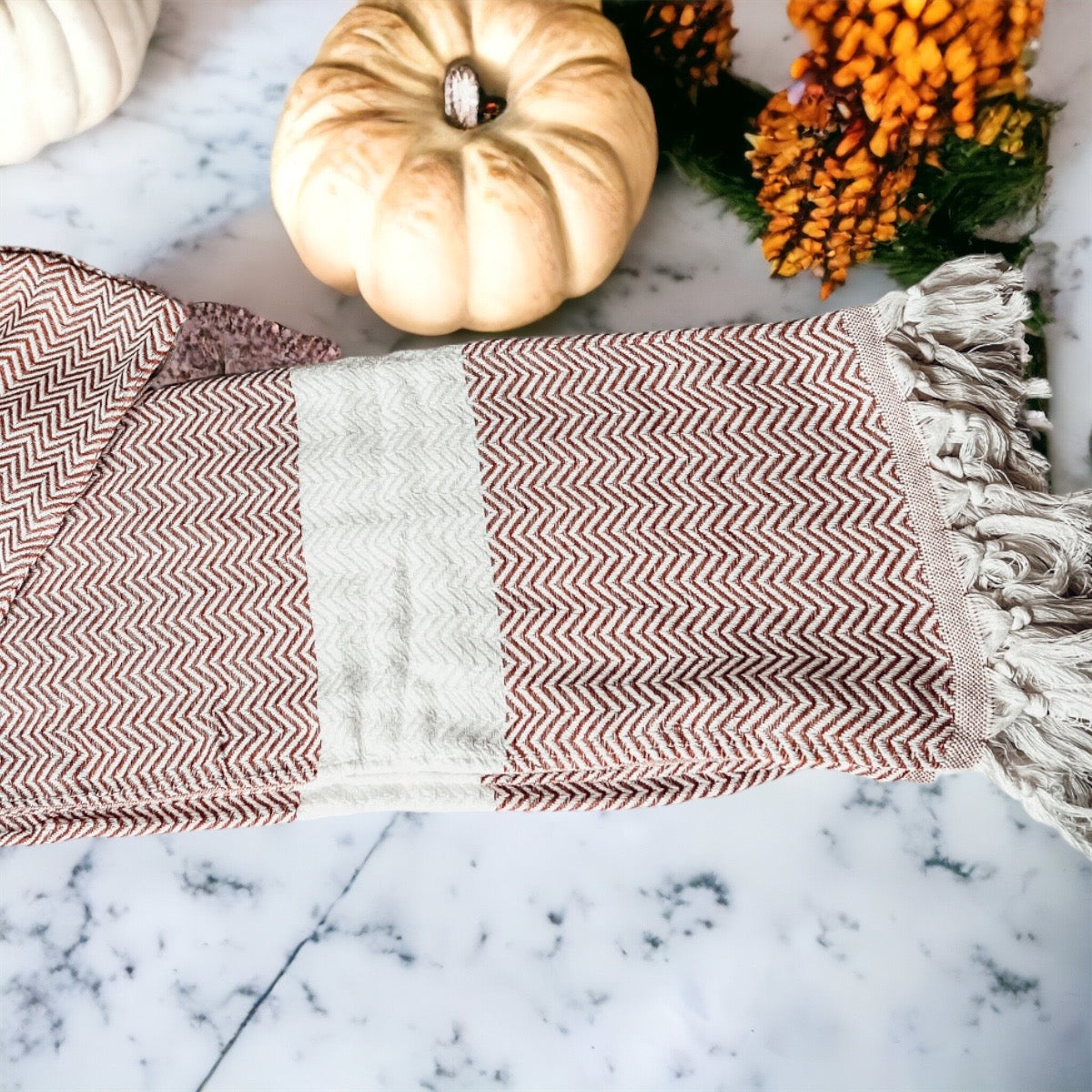 Chevron Towel made from 200 GSM Turkish cotton, featuring decorative tassels and available in blue, gray, and rust colors.