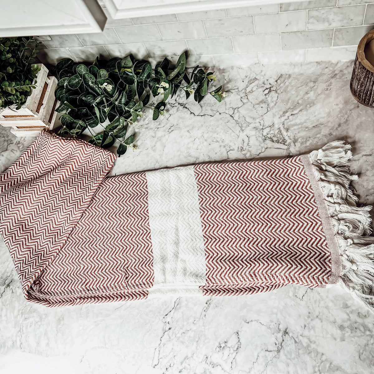 Chevron Towel made from 200 GSM Turkish cotton, featuring decorative tassels and available in blue, gray, and rust colors.