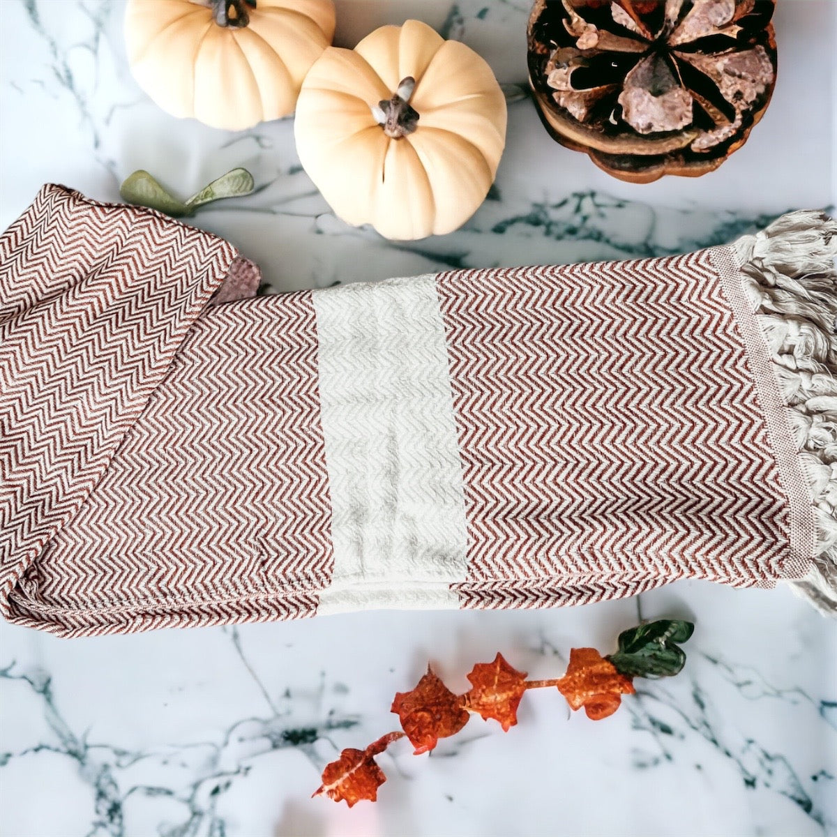 Chevron Towel made from 200 GSM Turkish cotton, featuring decorative tassels and available in blue, gray, and rust colors.