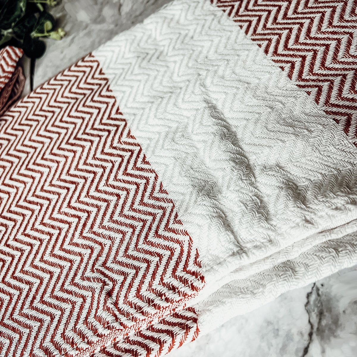 Chevron Towel made from 200 GSM Turkish cotton, featuring decorative tassels and available in blue, gray, and rust colors.