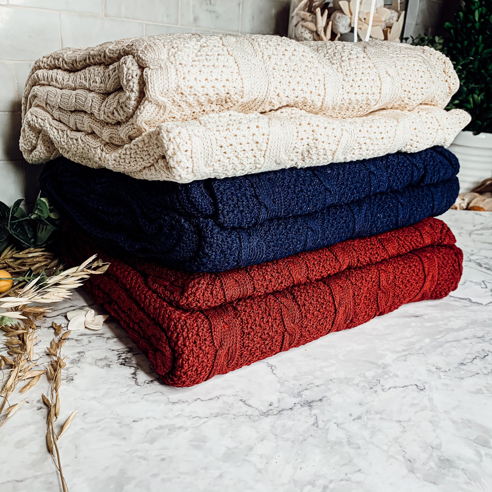 Cozy Claret Knit Sweater Throw blanket draped elegantly on a couch, showcasing its rich color and soft texture.