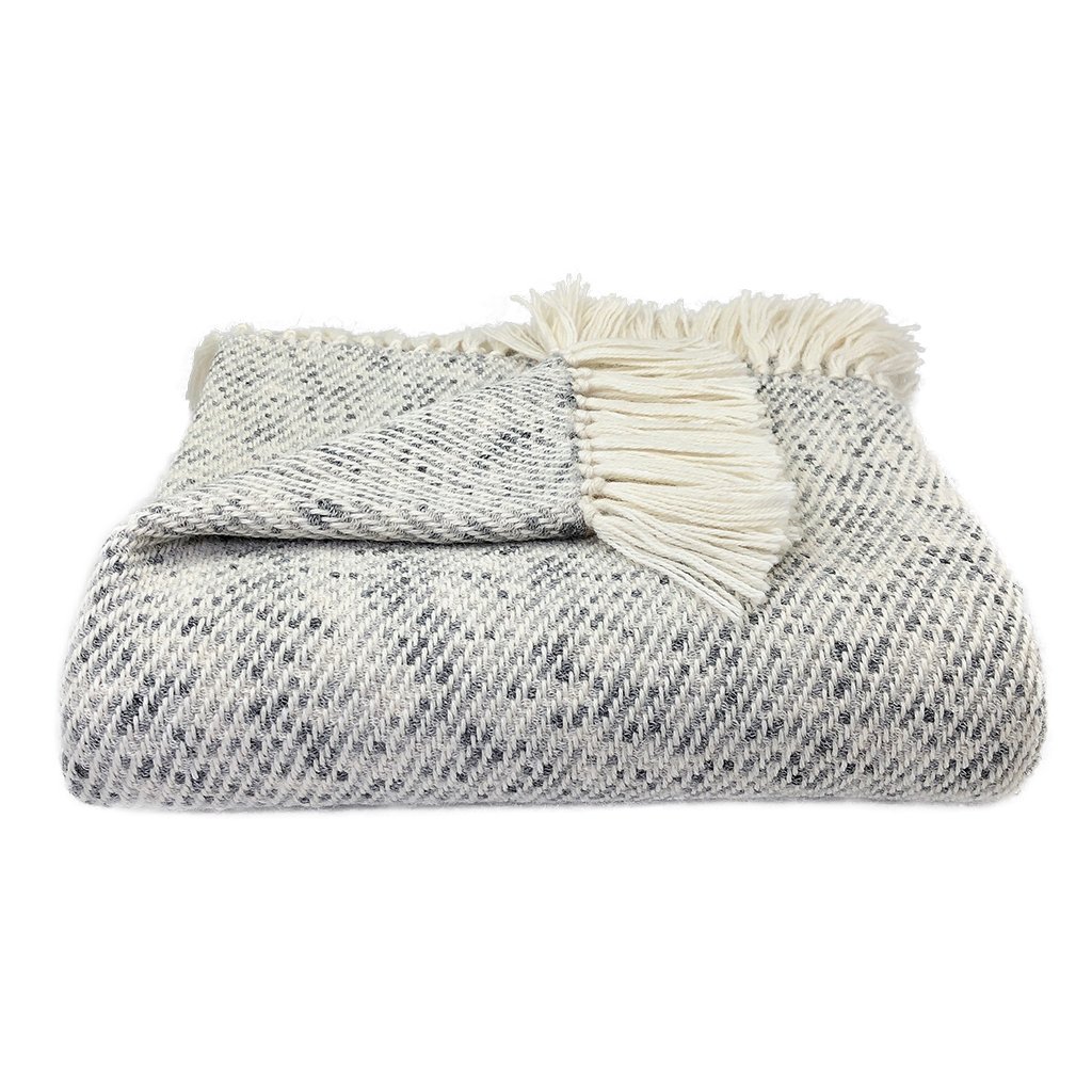 Heathered Gray Alpaca Throw draped elegantly on a sofa, showcasing its luxurious texture and neutral colors.