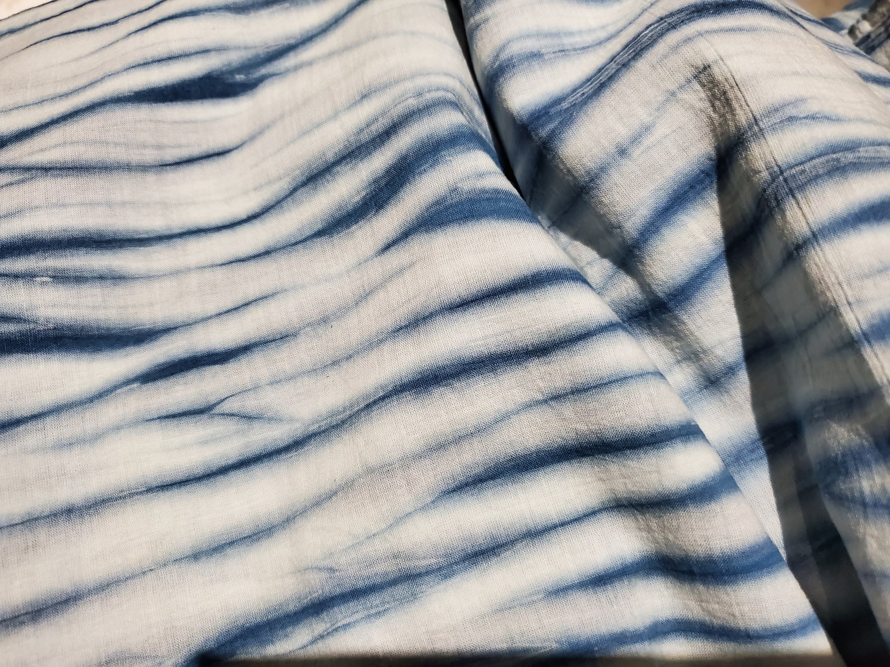 Indigo dyed hand printed cotton fabric featuring unique stripes on a white background, showcasing artisan craftsmanship.