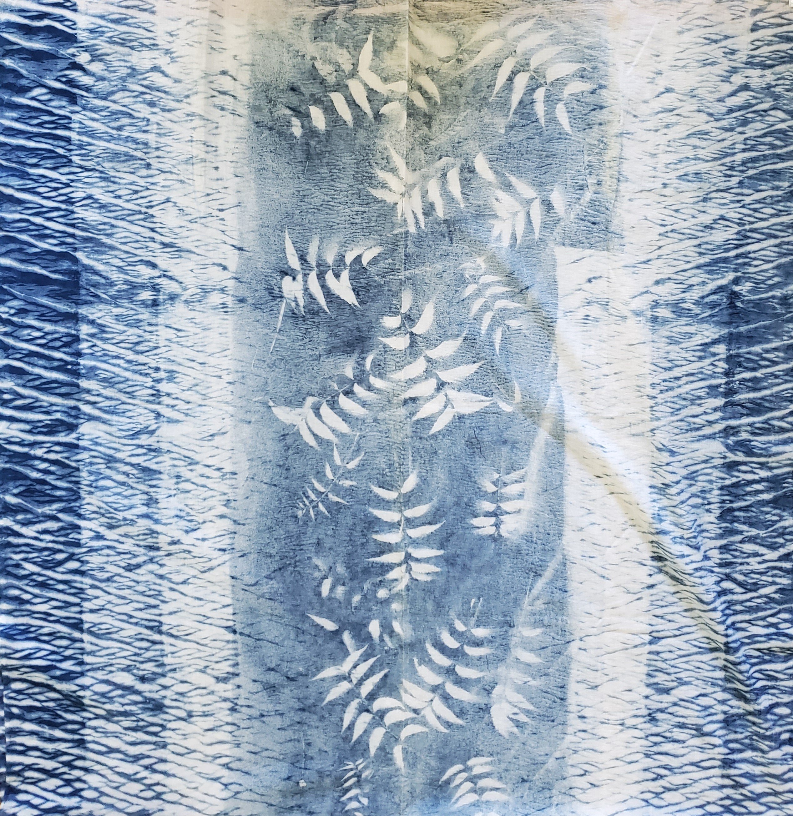 Indigo dyed hand printed cotton fabric featuring unique stripes on a white background, showcasing artisan craftsmanship.