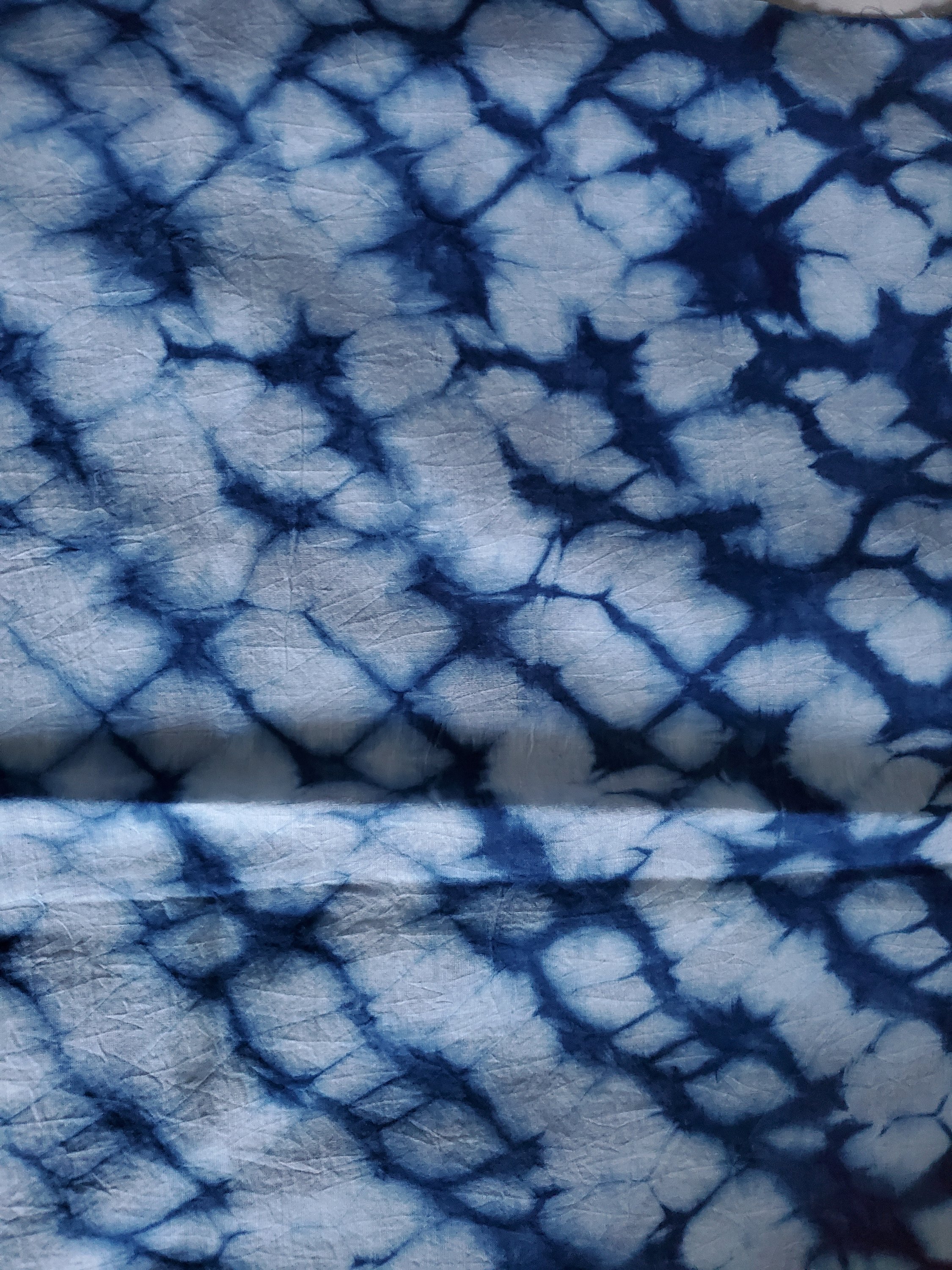 Indigo dyed hand printed cotton fabric featuring unique stripes on a white background, showcasing artisan craftsmanship.