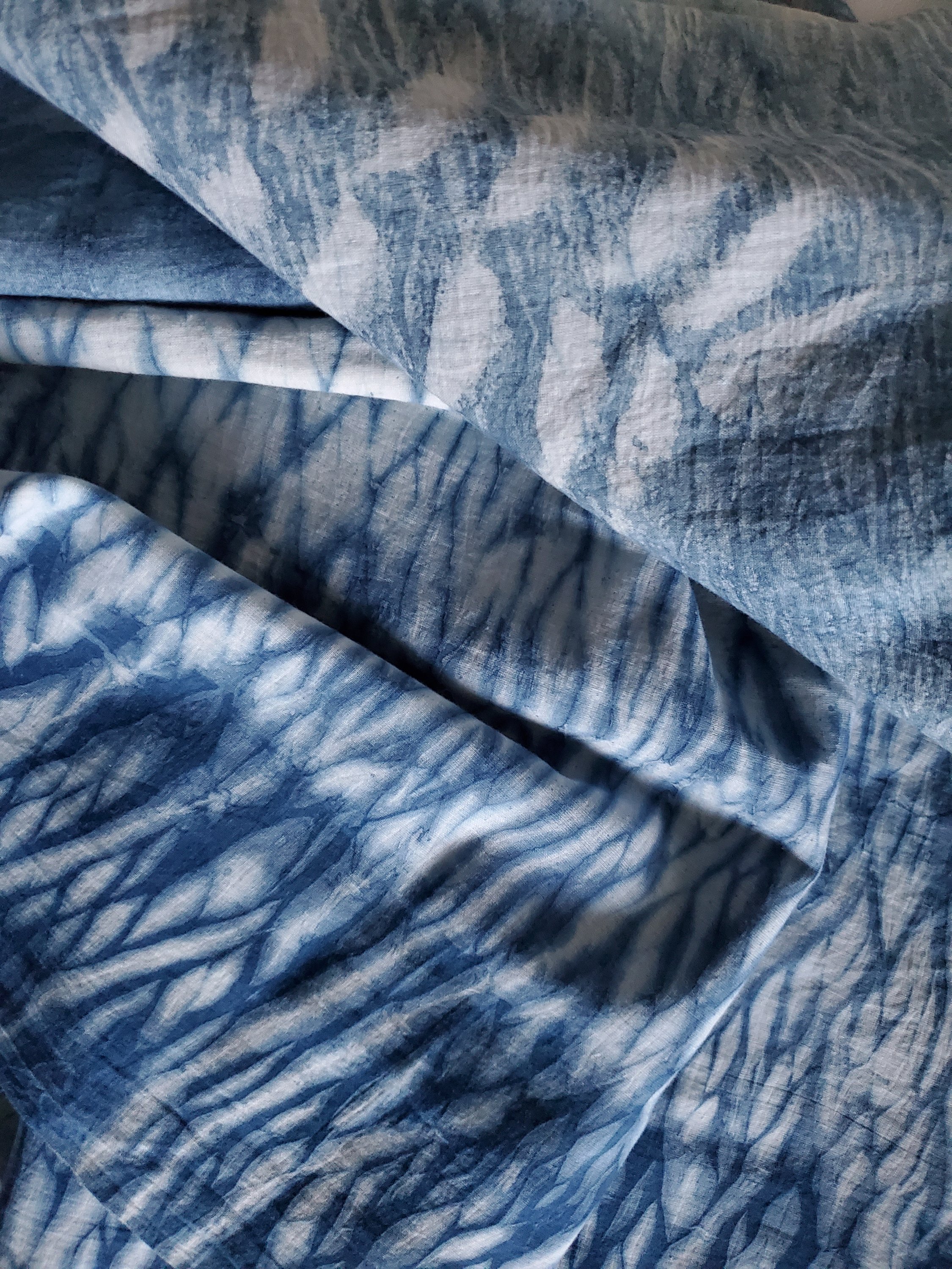 Indigo dyed hand printed cotton fabric featuring unique stripes on a white background, showcasing artisan craftsmanship.