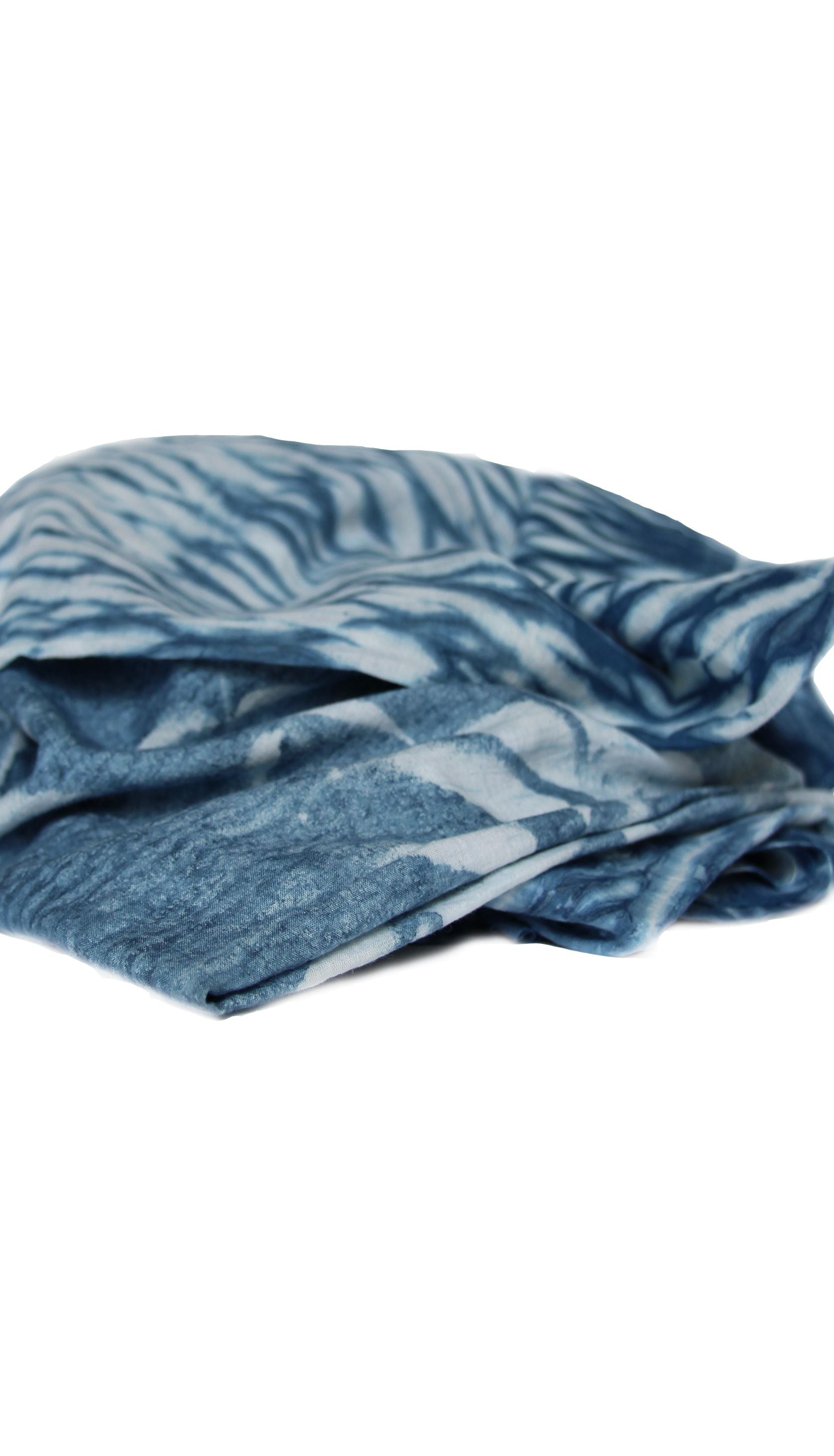 Indigo dyed hand printed cotton fabric featuring unique stripes on a white background, showcasing artisan craftsmanship.