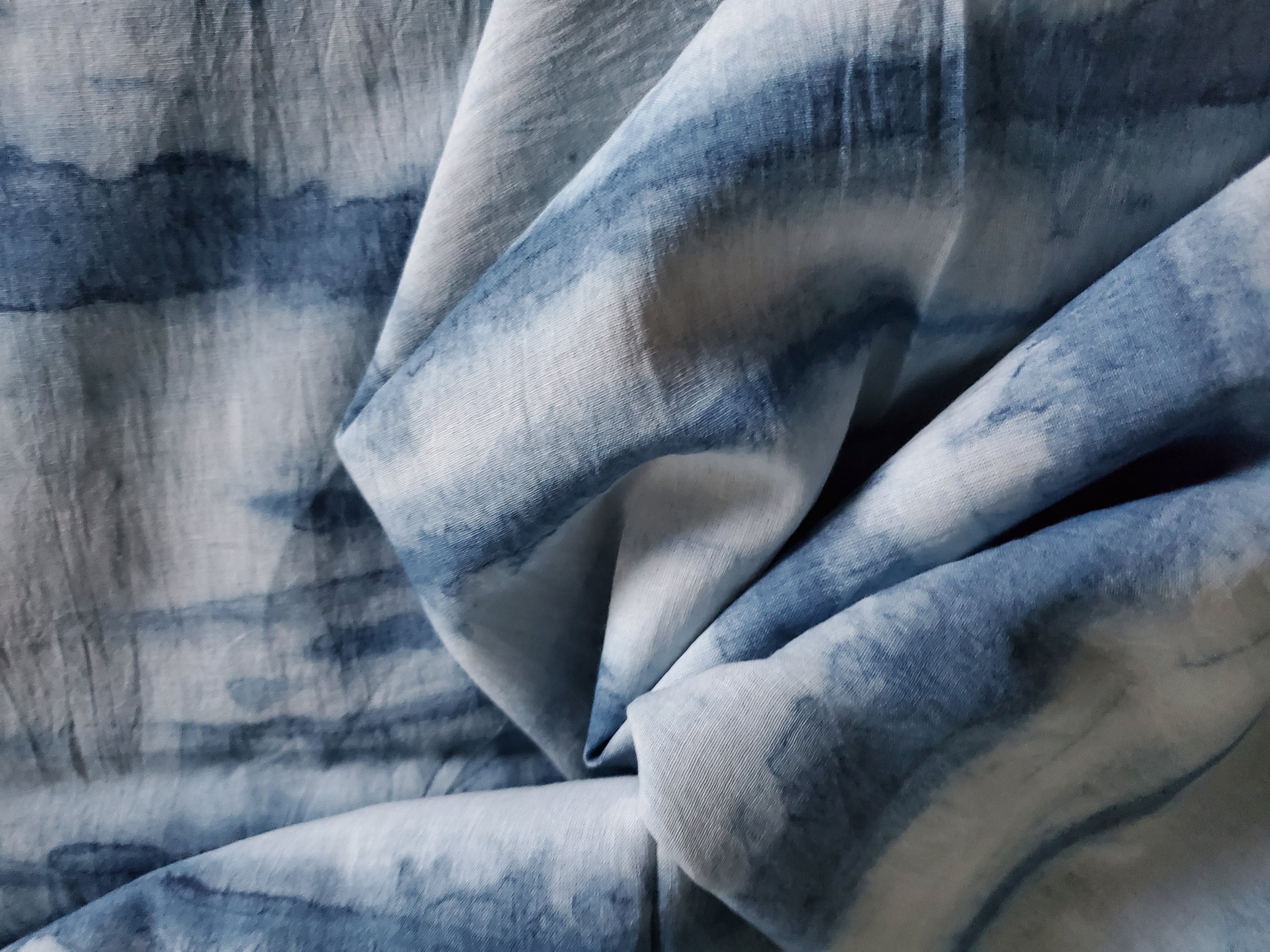 Indigo dyed hand printed cotton fabric featuring unique stripes on a white background, showcasing artisan craftsmanship.