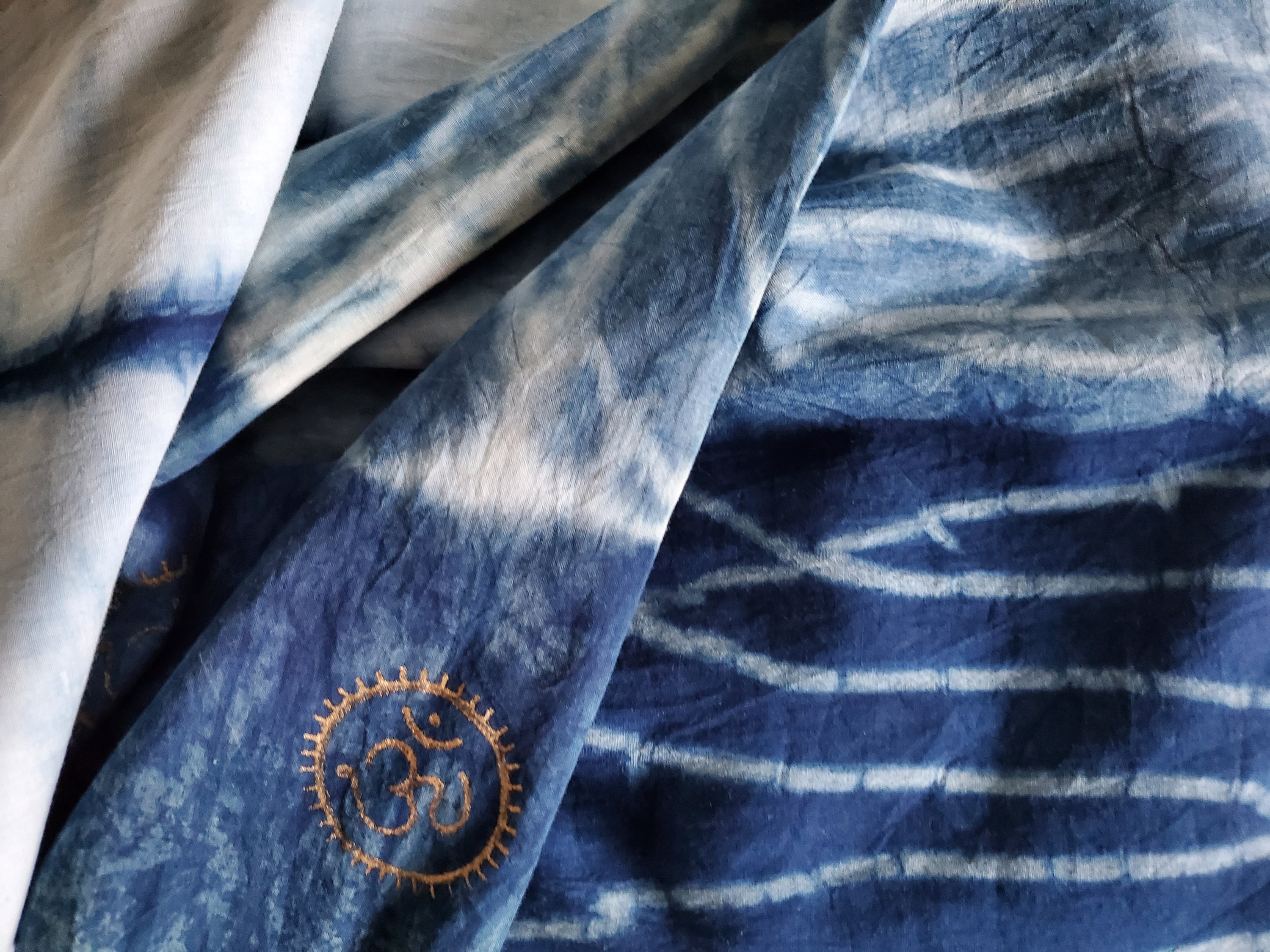 Indigo dyed hand printed cotton fabric featuring unique stripes on a white background, showcasing artisan craftsmanship.