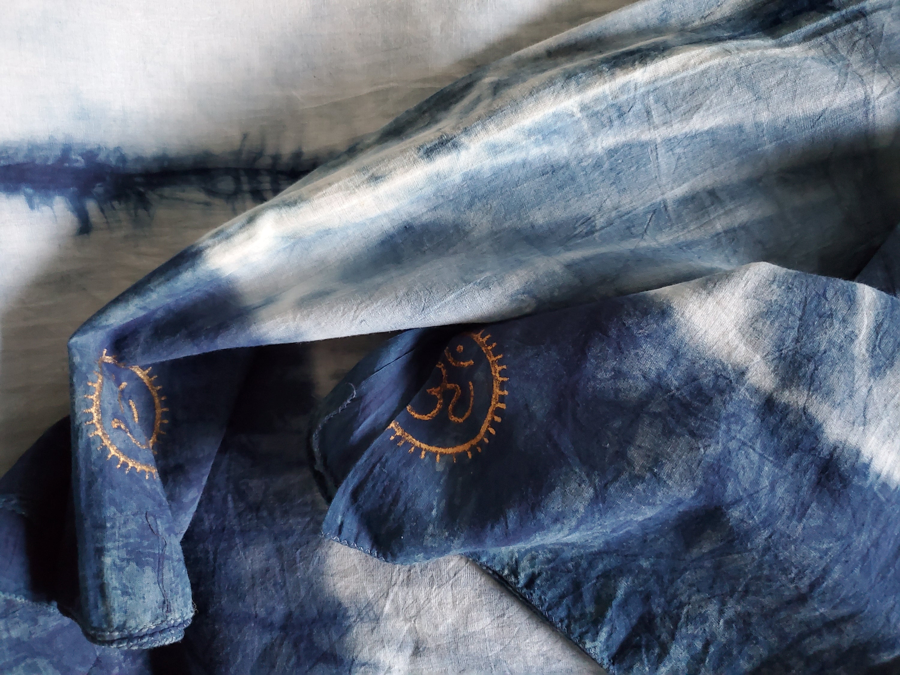 Indigo dyed hand printed cotton fabric featuring unique stripes on a white background, showcasing artisan craftsmanship.