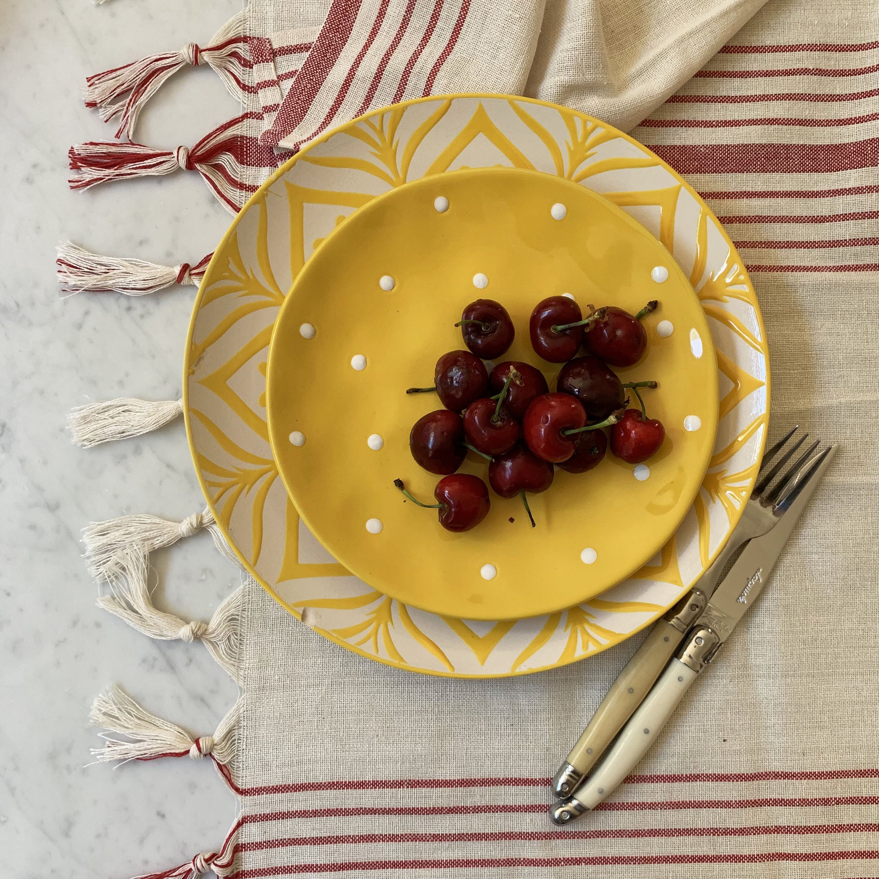 Kayseri Tablecloth Set in Red featuring a Mediterranean design with hand-tied tassels and woven French stripes, perfect for elegant dining.