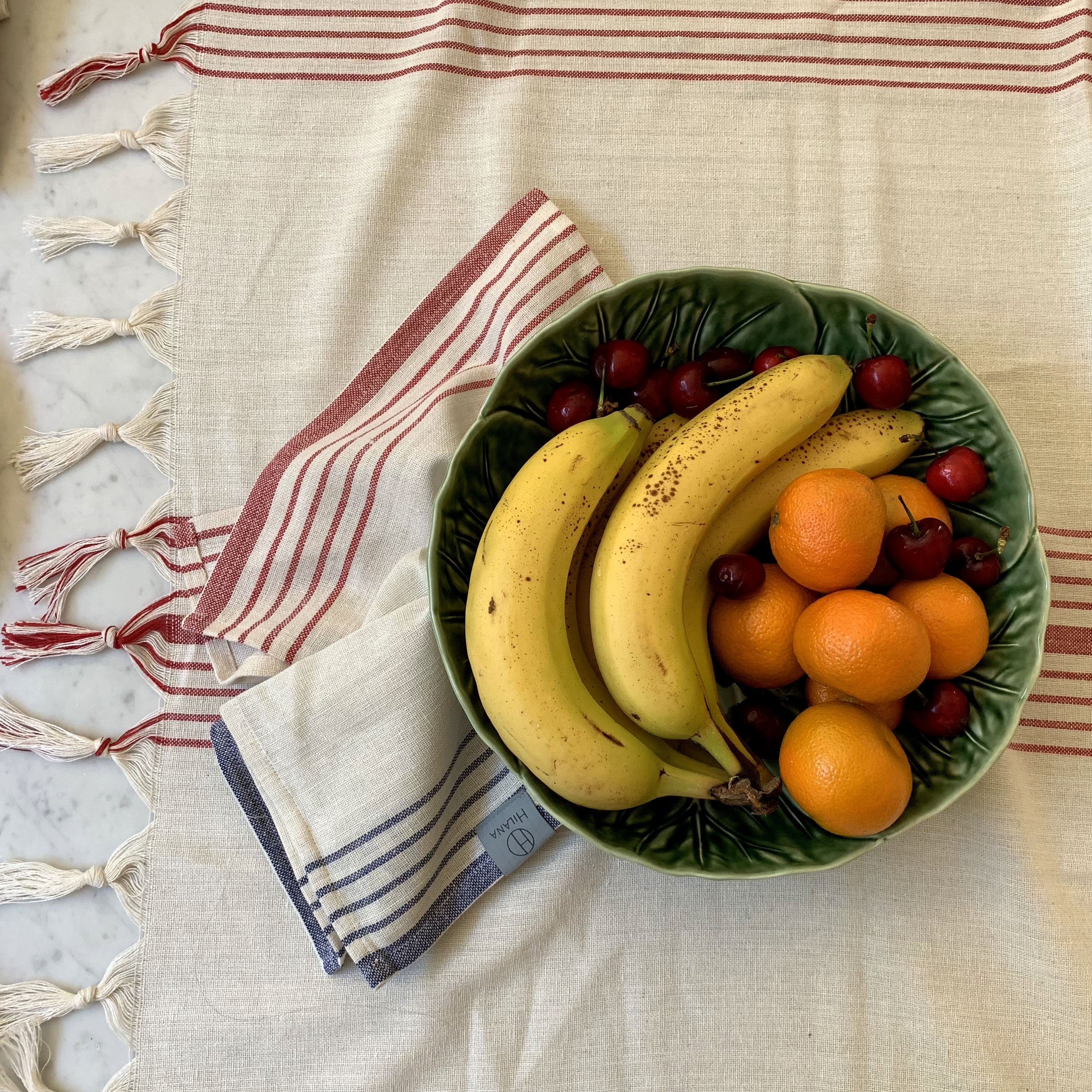 Kayseri Tablecloth Set in Red featuring a Mediterranean design with hand-tied tassels and woven French stripes, perfect for elegant dining.