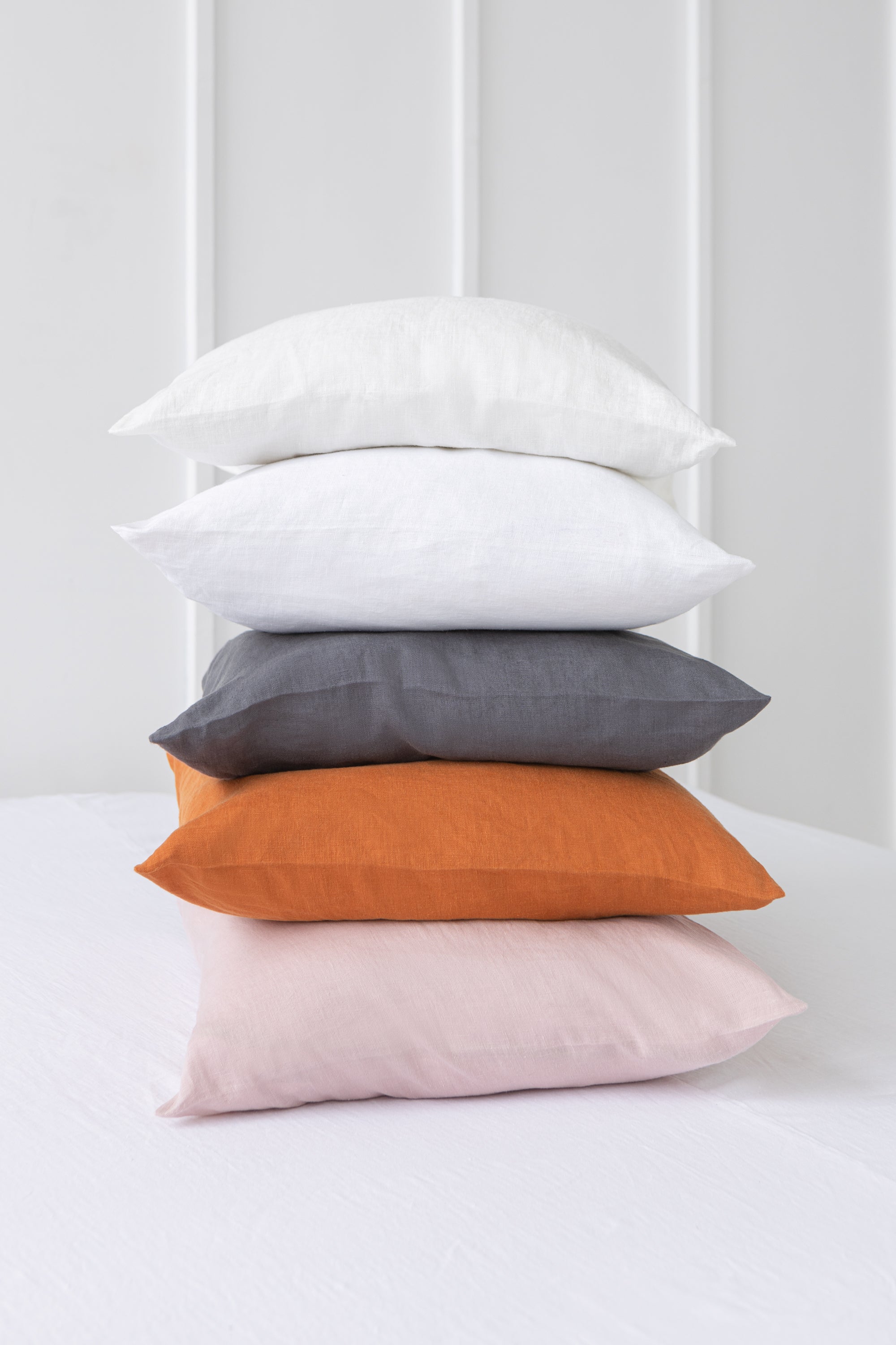 Elegant linen pillow cases with envelope closure, showcasing soft texture and natural fabric in various colors.