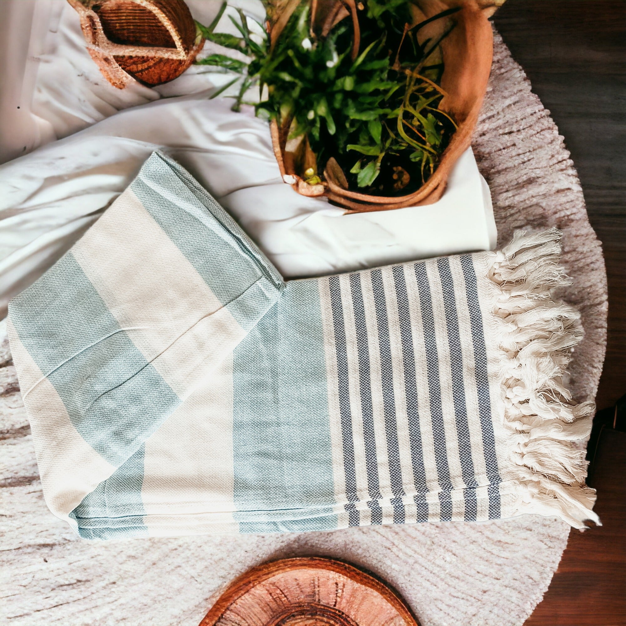 A collection of Mediterranean towels in various colors including light blue, gray, navy, and pink, featuring decorative tassels.