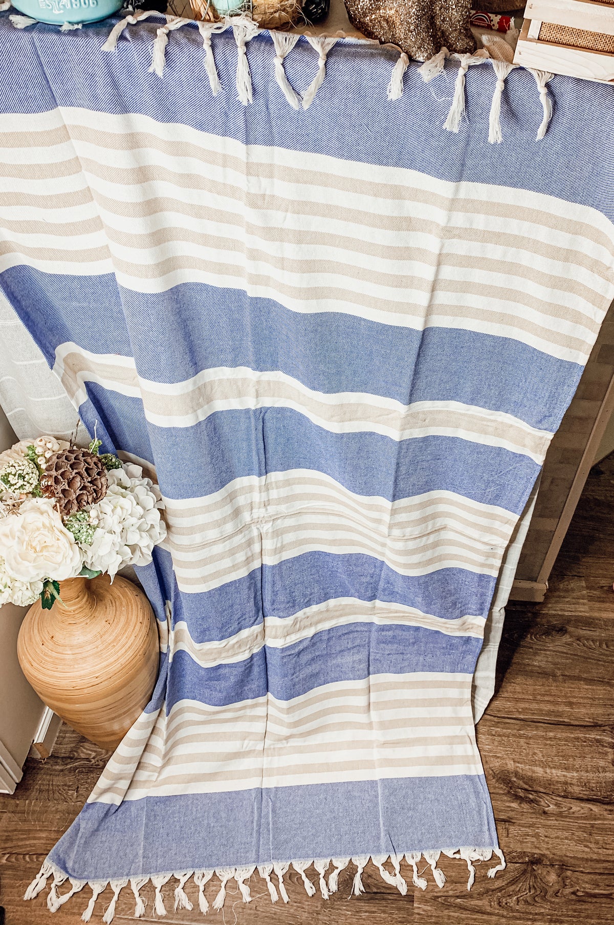 A collection of Mediterranean towels in various colors including light blue, gray, navy, and pink, featuring decorative tassels.