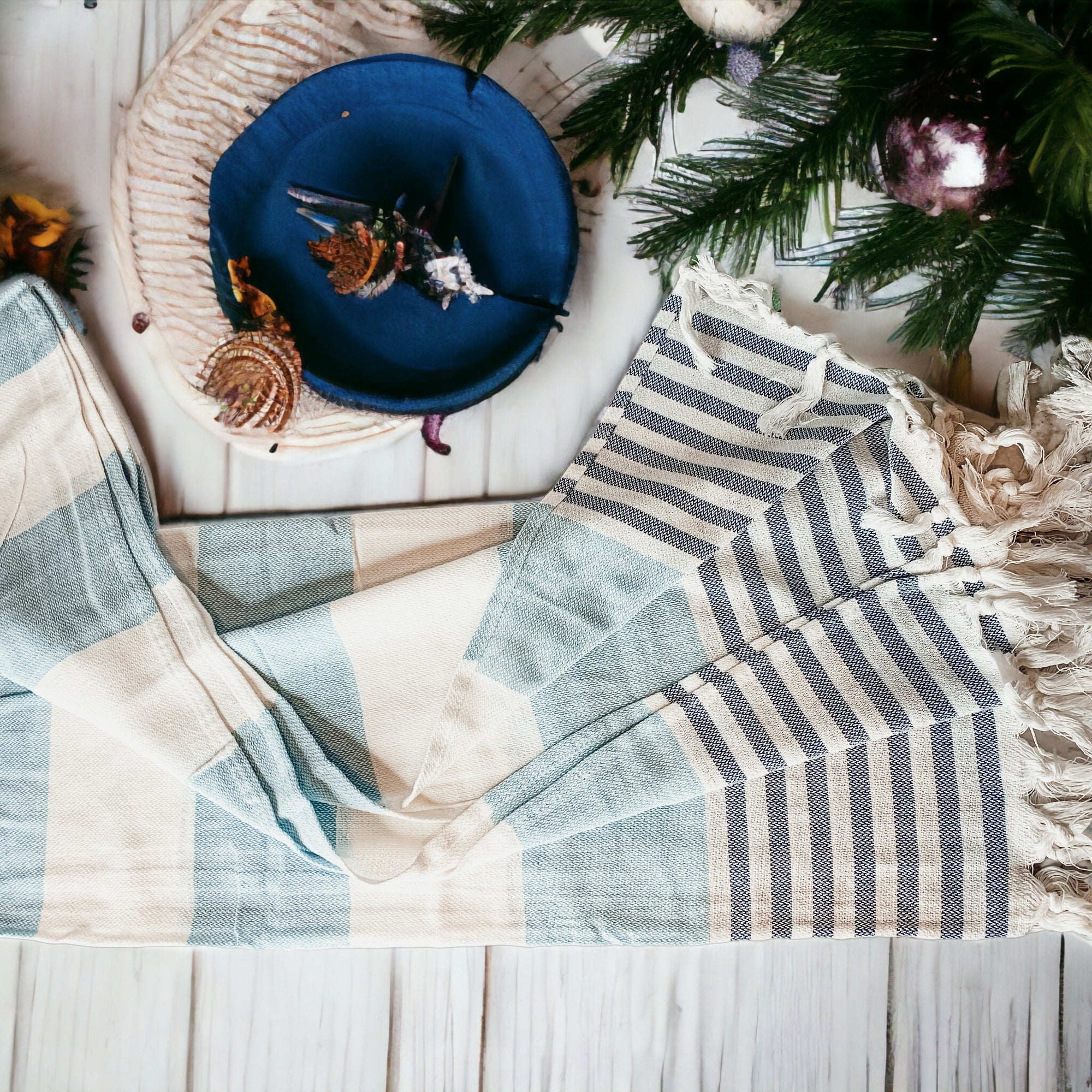 A collection of Mediterranean towels in various colors including light blue, gray, navy, and pink, featuring decorative tassels.