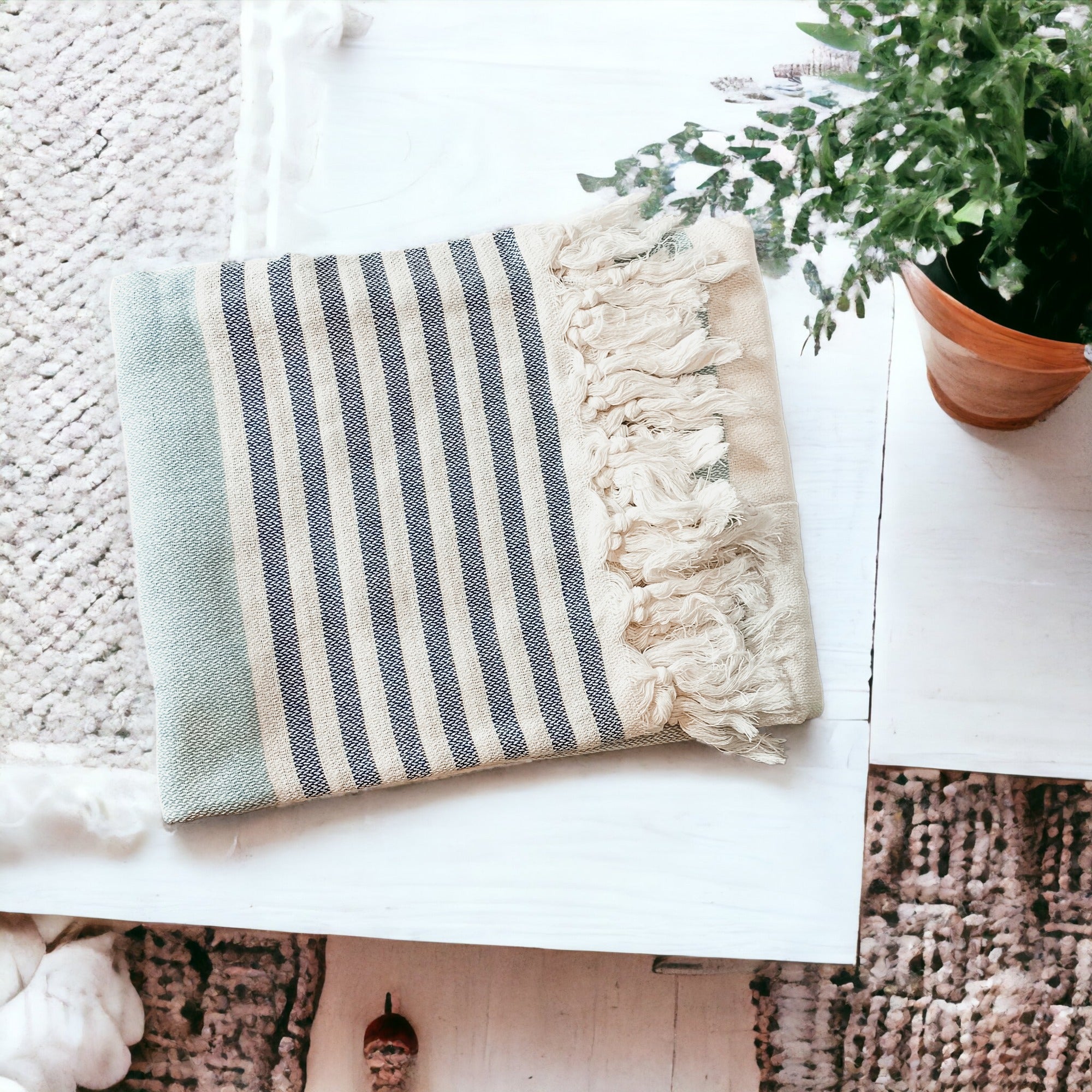 A collection of Mediterranean towels in various colors including light blue, gray, navy, and pink, featuring decorative tassels.