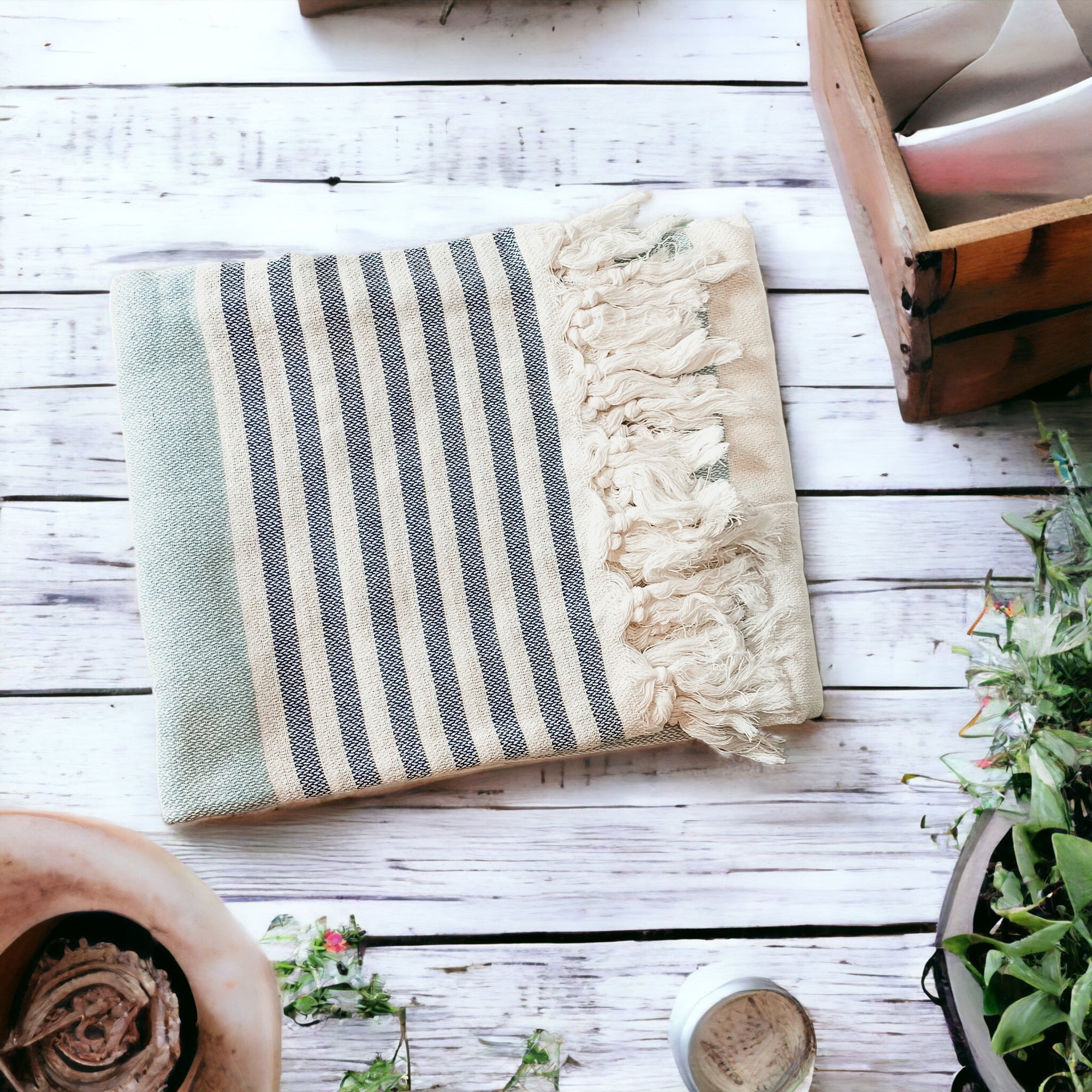 A collection of Mediterranean towels in various colors including light blue, gray, navy, and pink, featuring decorative tassels.