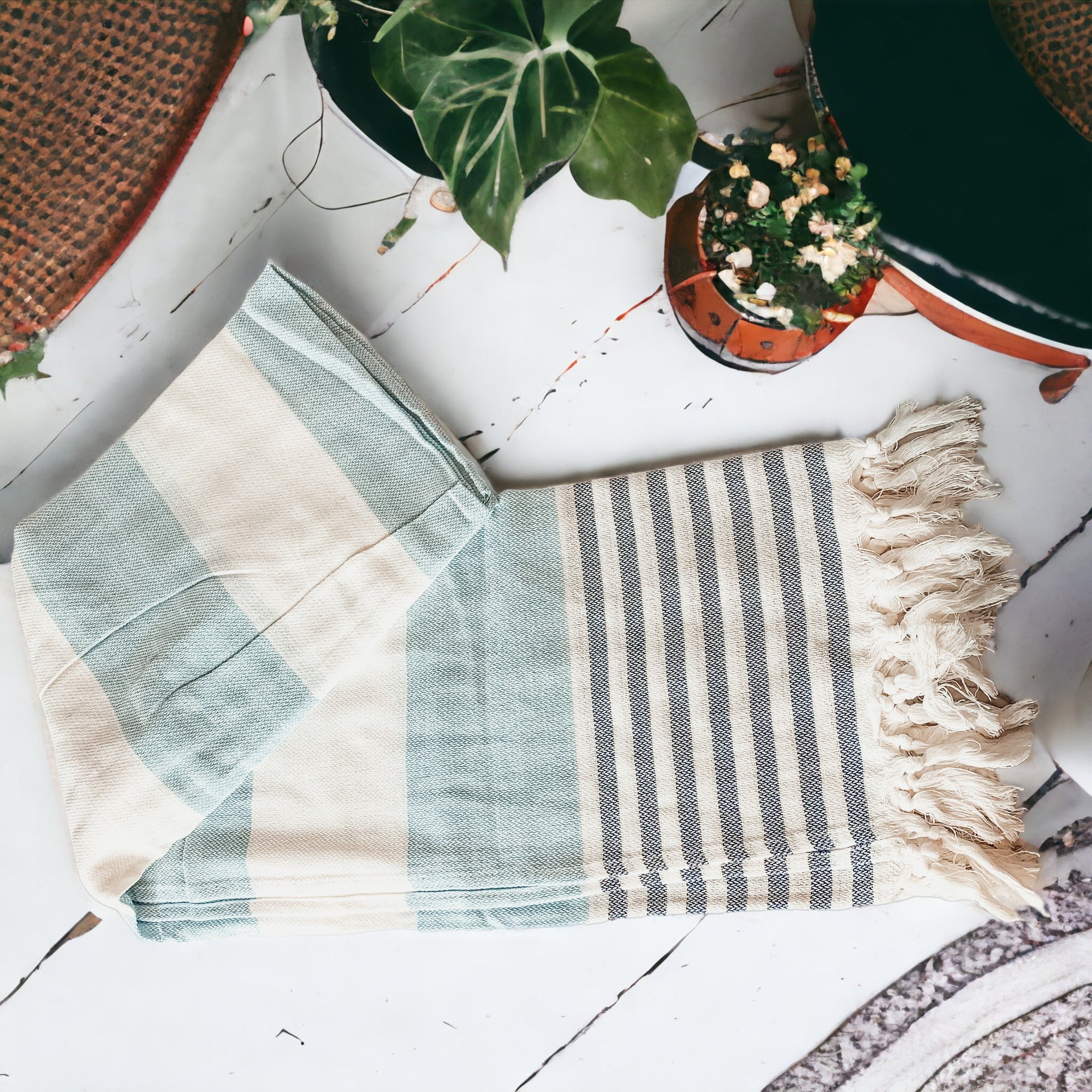 A collection of Mediterranean towels in various colors including light blue, gray, navy, and pink, featuring decorative tassels.