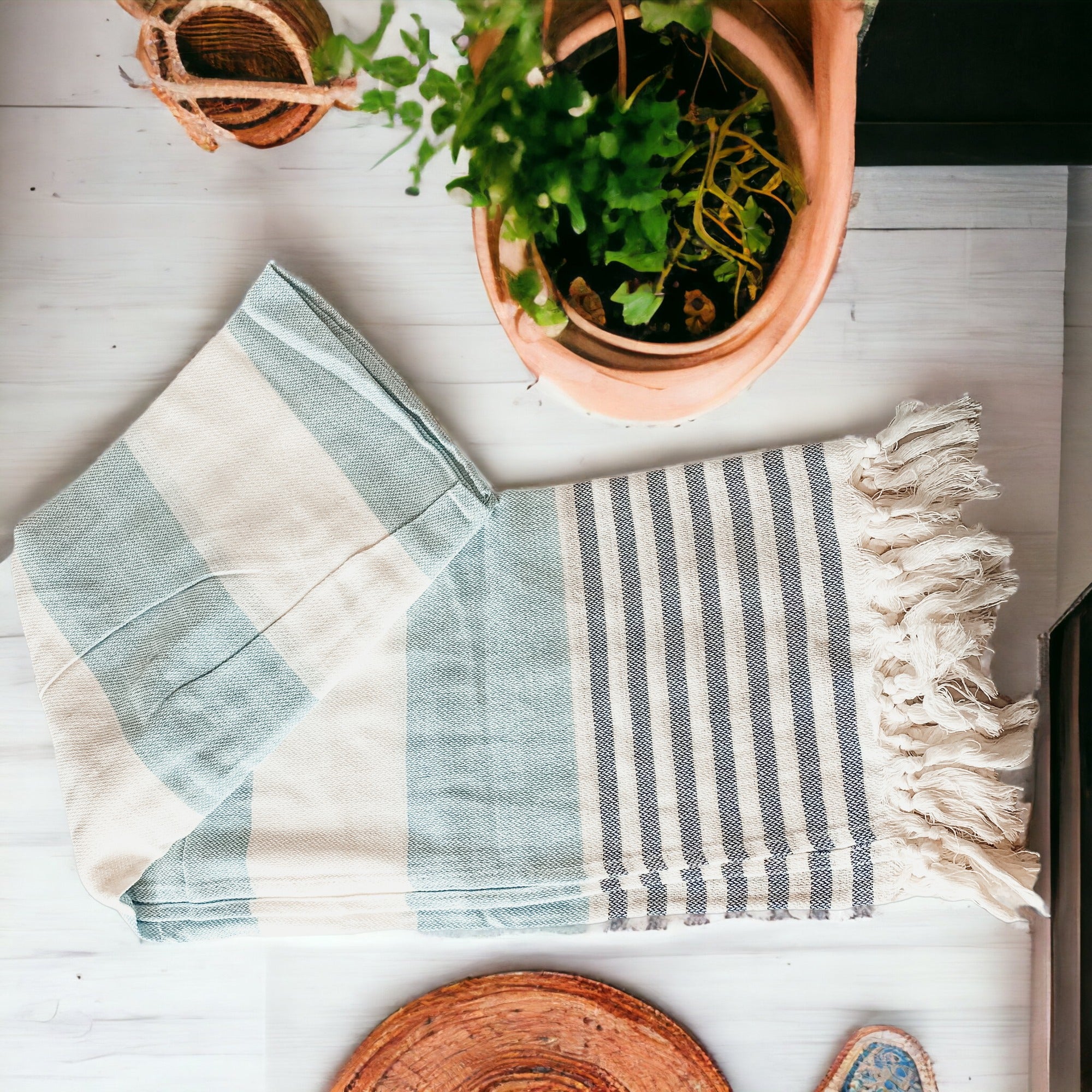 A collection of Mediterranean towels in various colors including light blue, gray, navy, and pink, featuring decorative tassels.