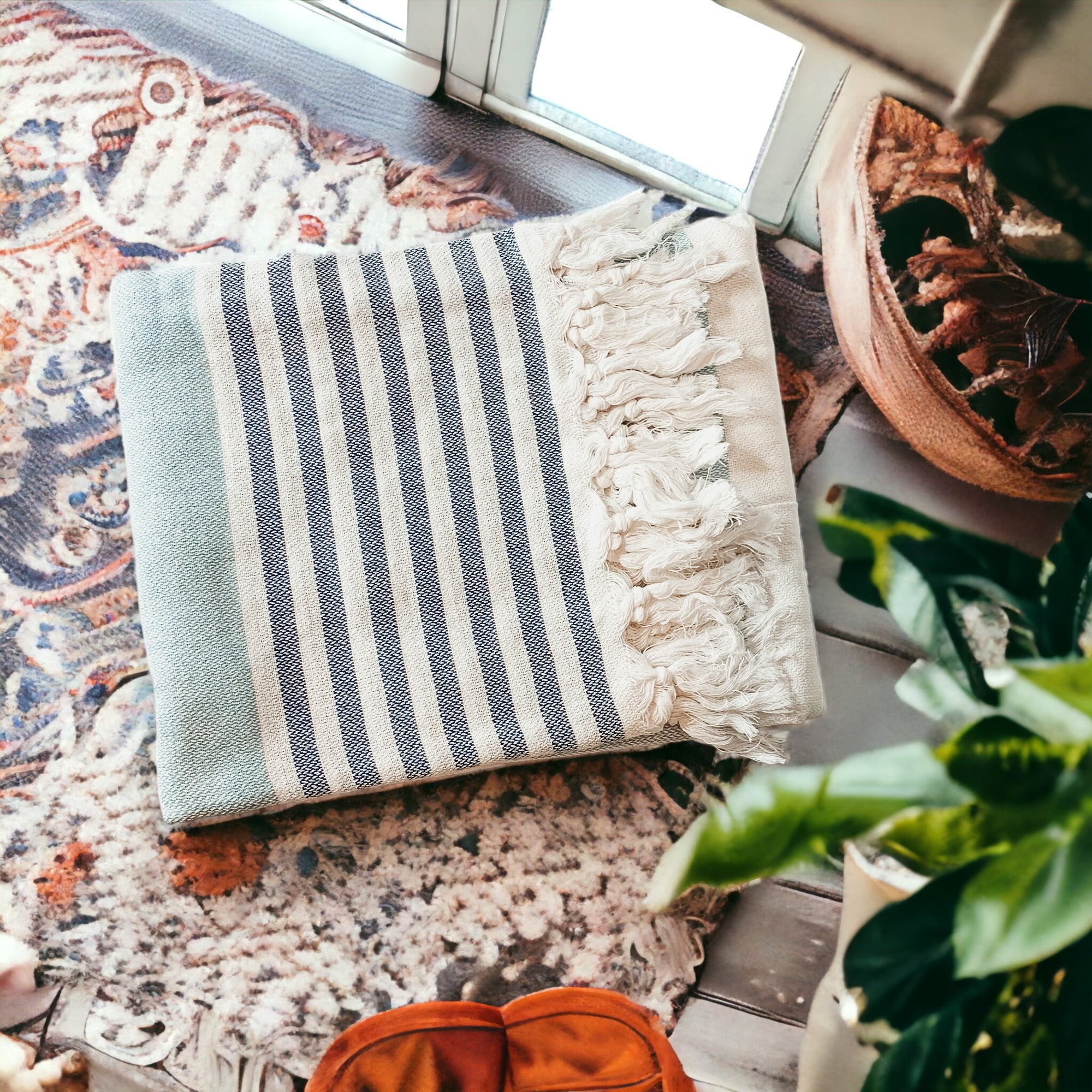 A collection of Mediterranean towels in various colors including light blue, gray, navy, and pink, featuring decorative tassels.