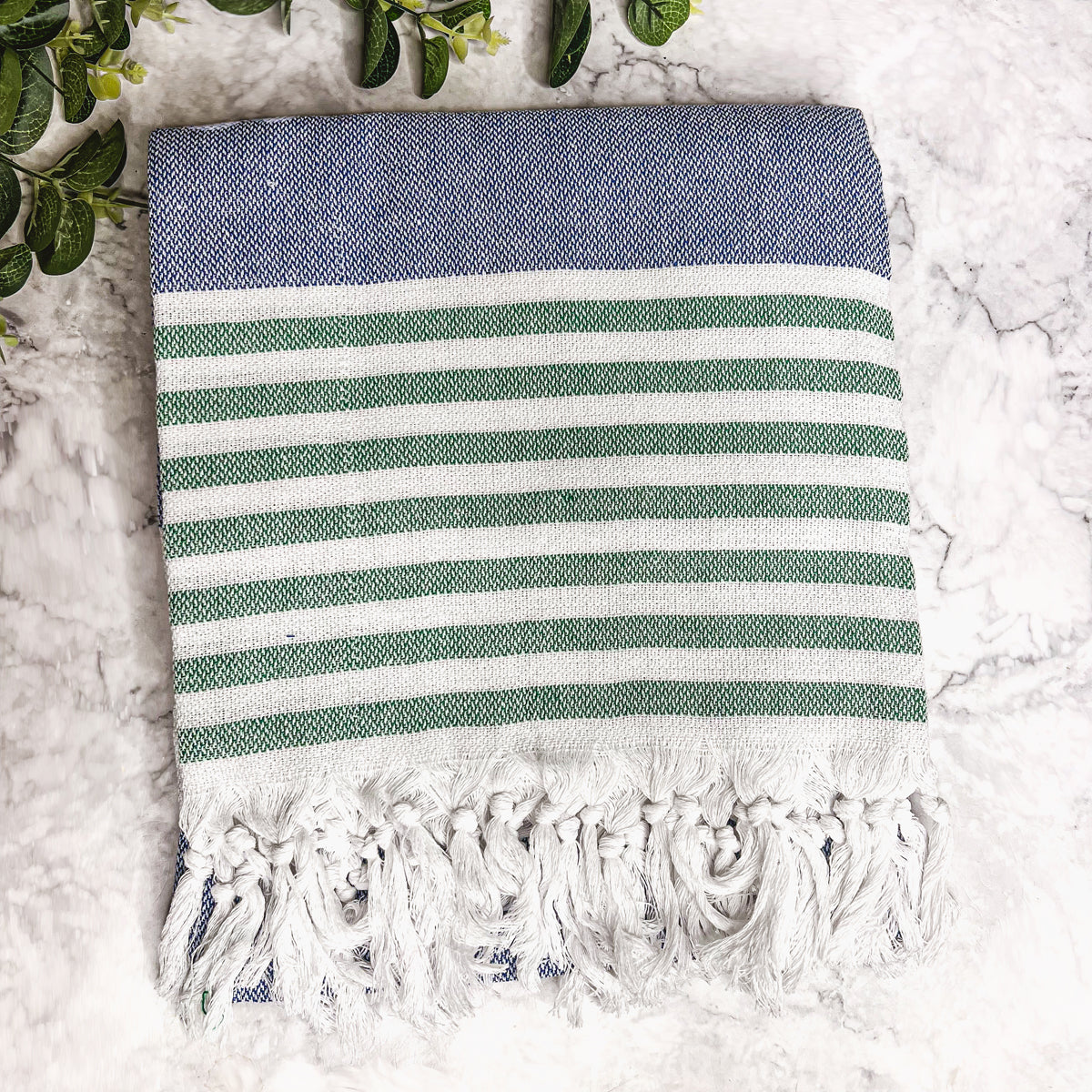 A collection of Mediterranean towels in various colors including light blue, gray, navy, and pink, featuring decorative tassels.