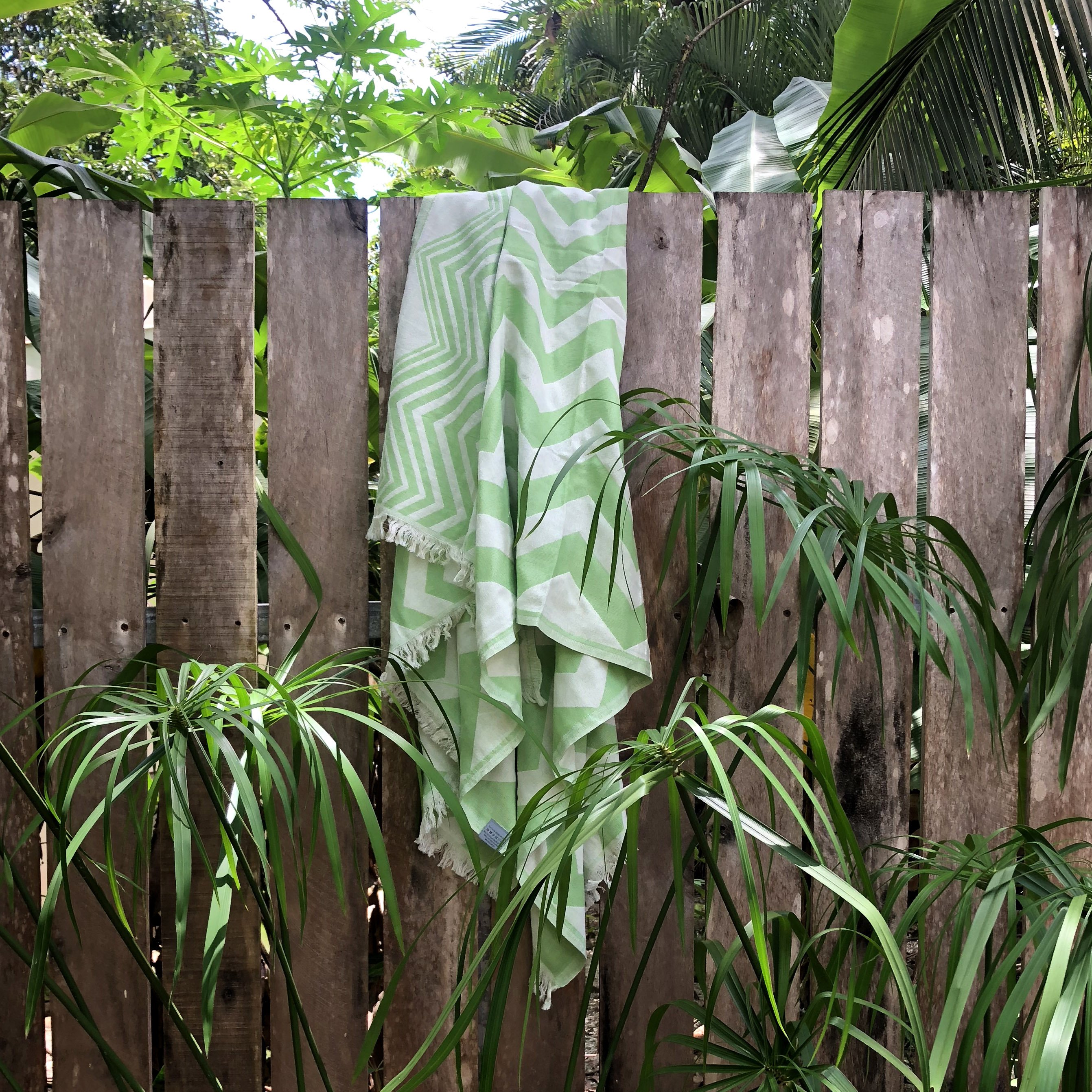 Mersin Chevron Towel in bright green with a chevron pattern, showcasing its soft texture and handcrafted tassels.