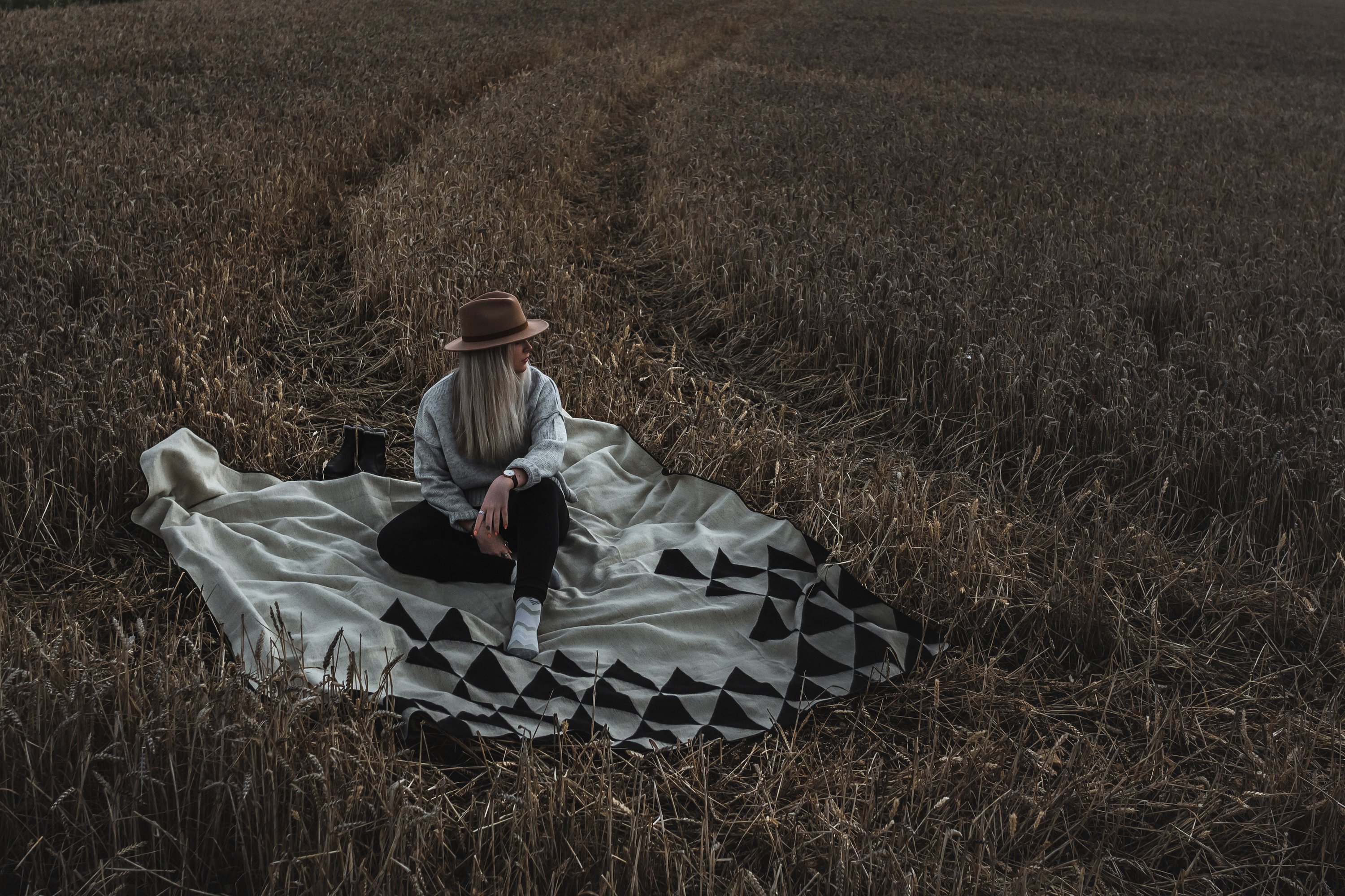 Nevado Blanket in natural and black colors, showcasing its soft texture and reversible design, perfect for cozying up or adding style to any space.