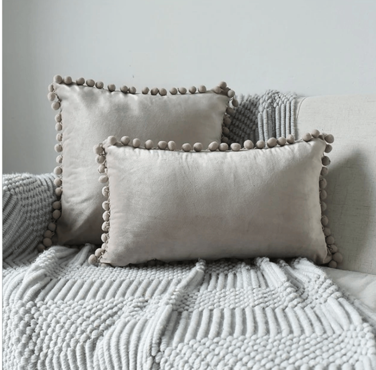 A cozy set of Plush Pom Poms pillows in soft velour material, perfect for cuddling or decorative use.