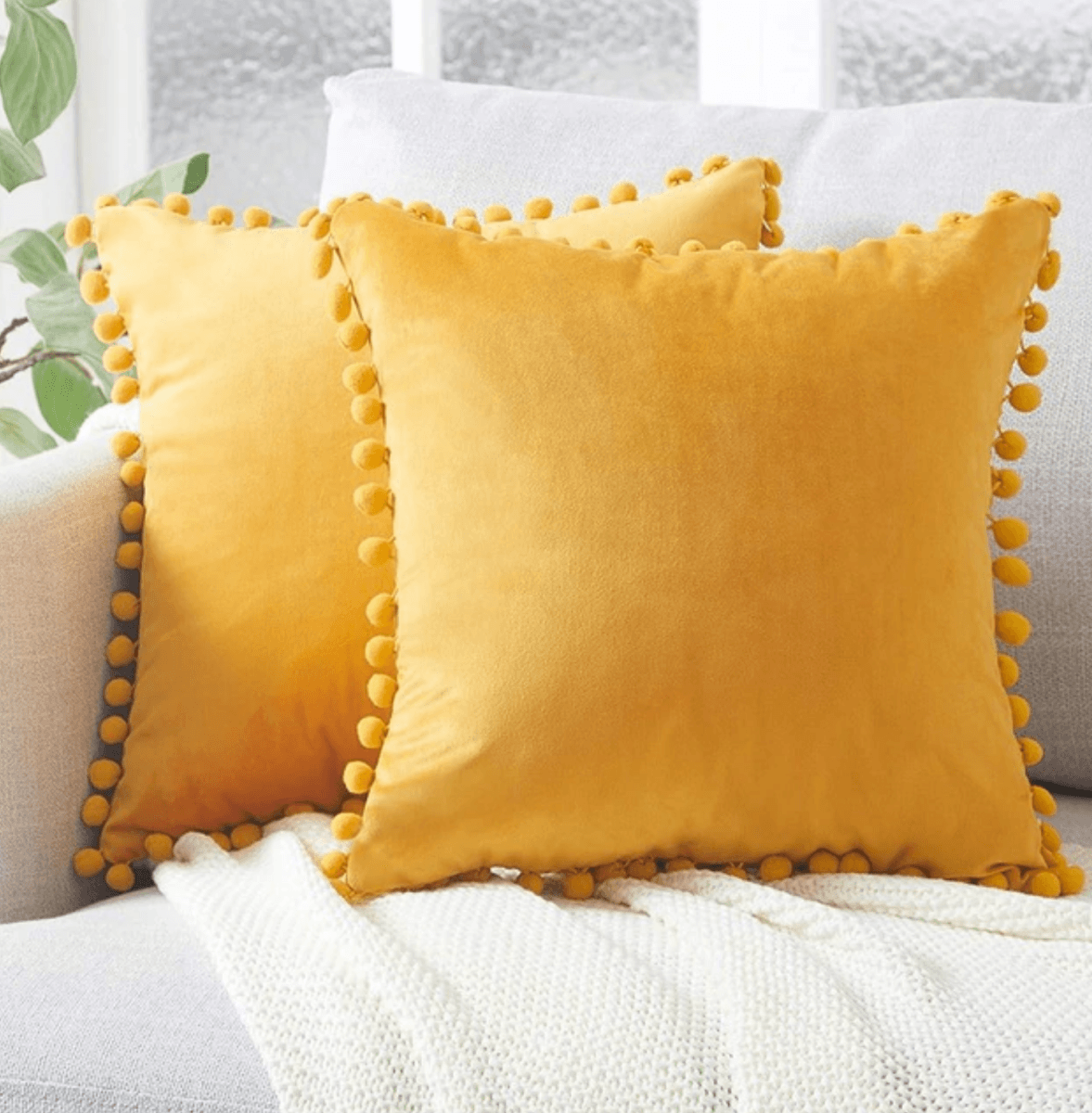 A cozy set of Plush Pom Poms pillows in soft velour material, perfect for cuddling or decorative use.