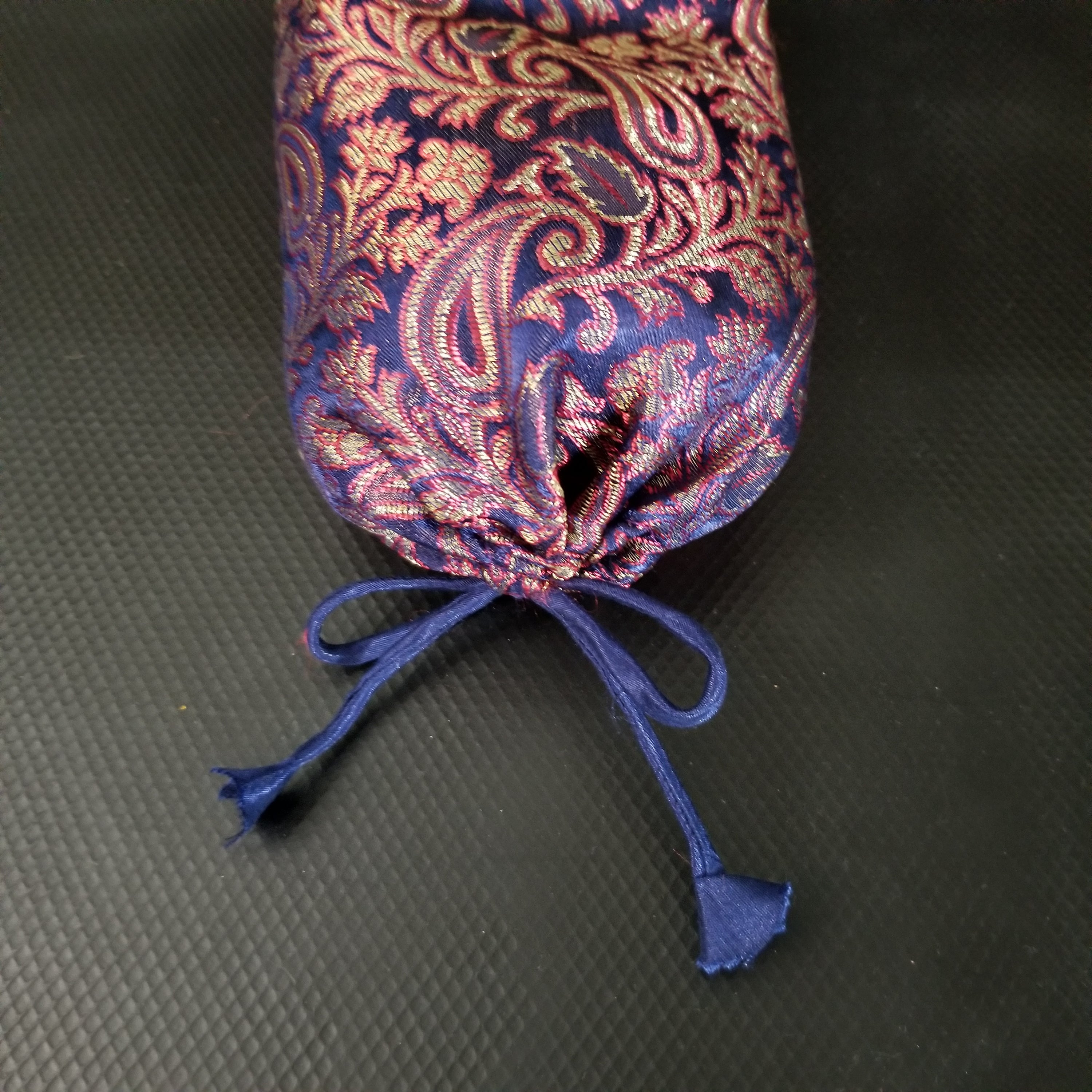 Silk Neck Pillow with paisley design, filled with organic buckwheat hulls, providing neck support for yoga and relaxation.