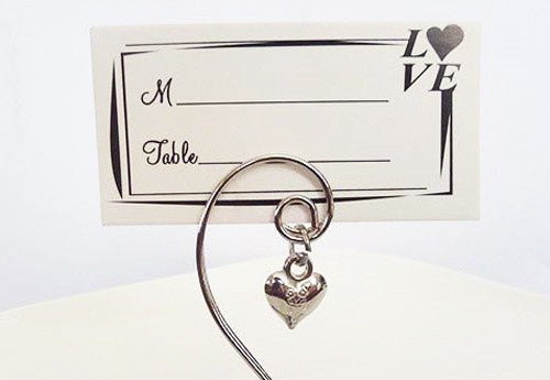 A set of 10 silver wedding kissing bells with heart name card holders, elegantly designed for table decorations.