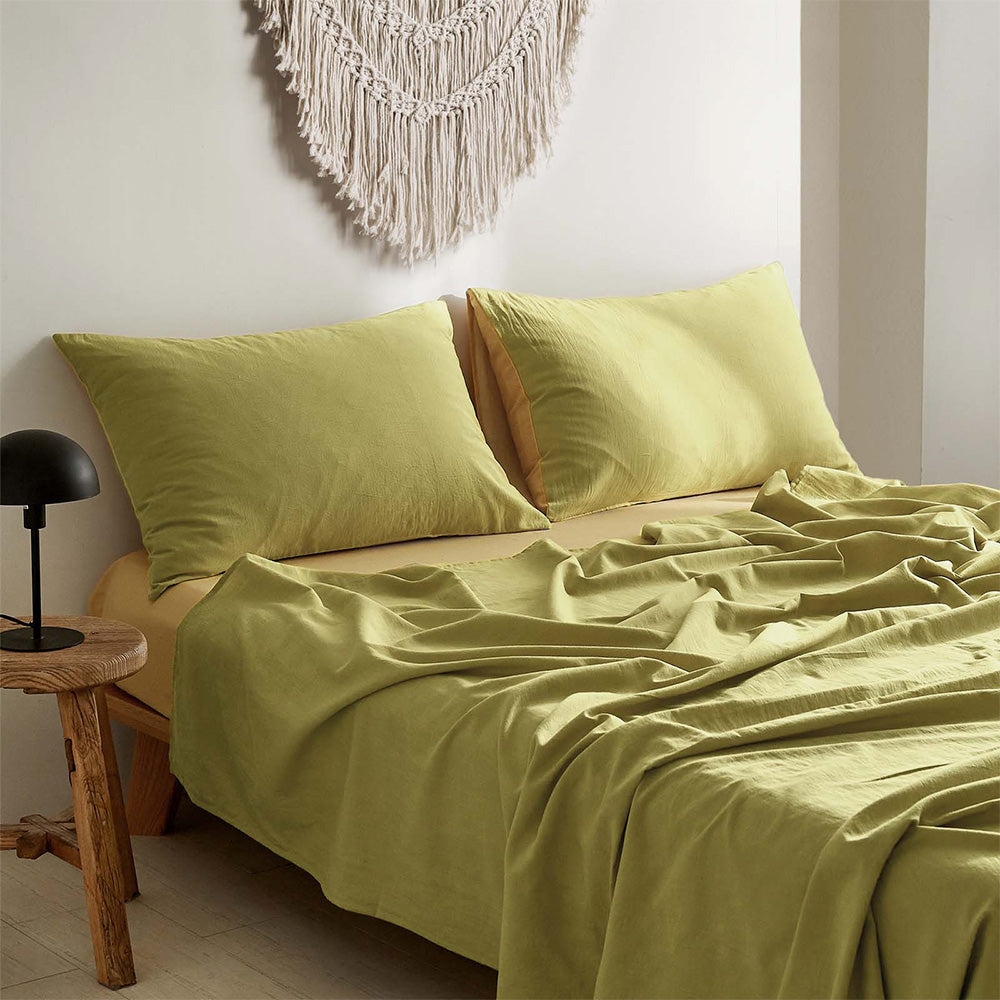 100% washed cotton bed sheet set in yellow, featuring a flat sheet, fitted sheet, and two pillow cases, showcasing a soft and breathable texture.