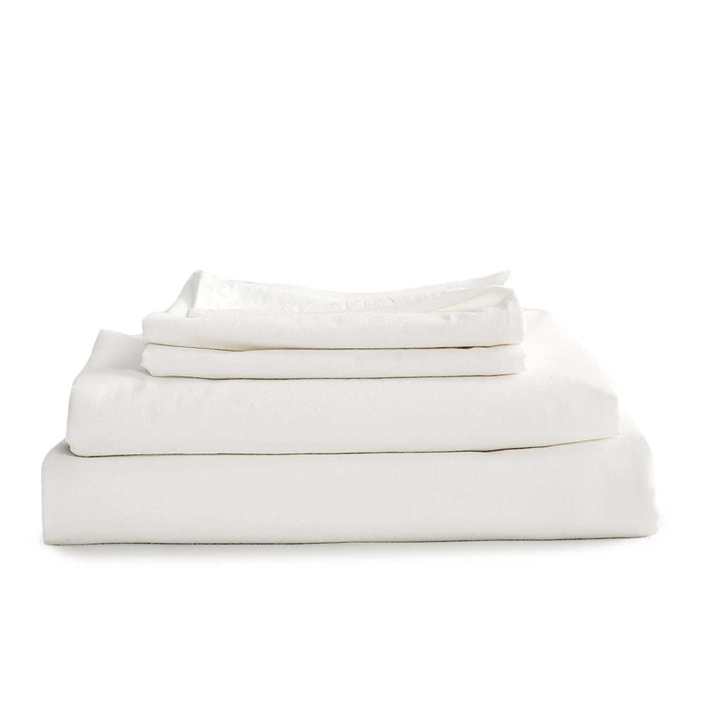 A luxurious 100% washed cotton sheet set in white, featuring a soft texture and lightweight design, perfect for all year round comfort.