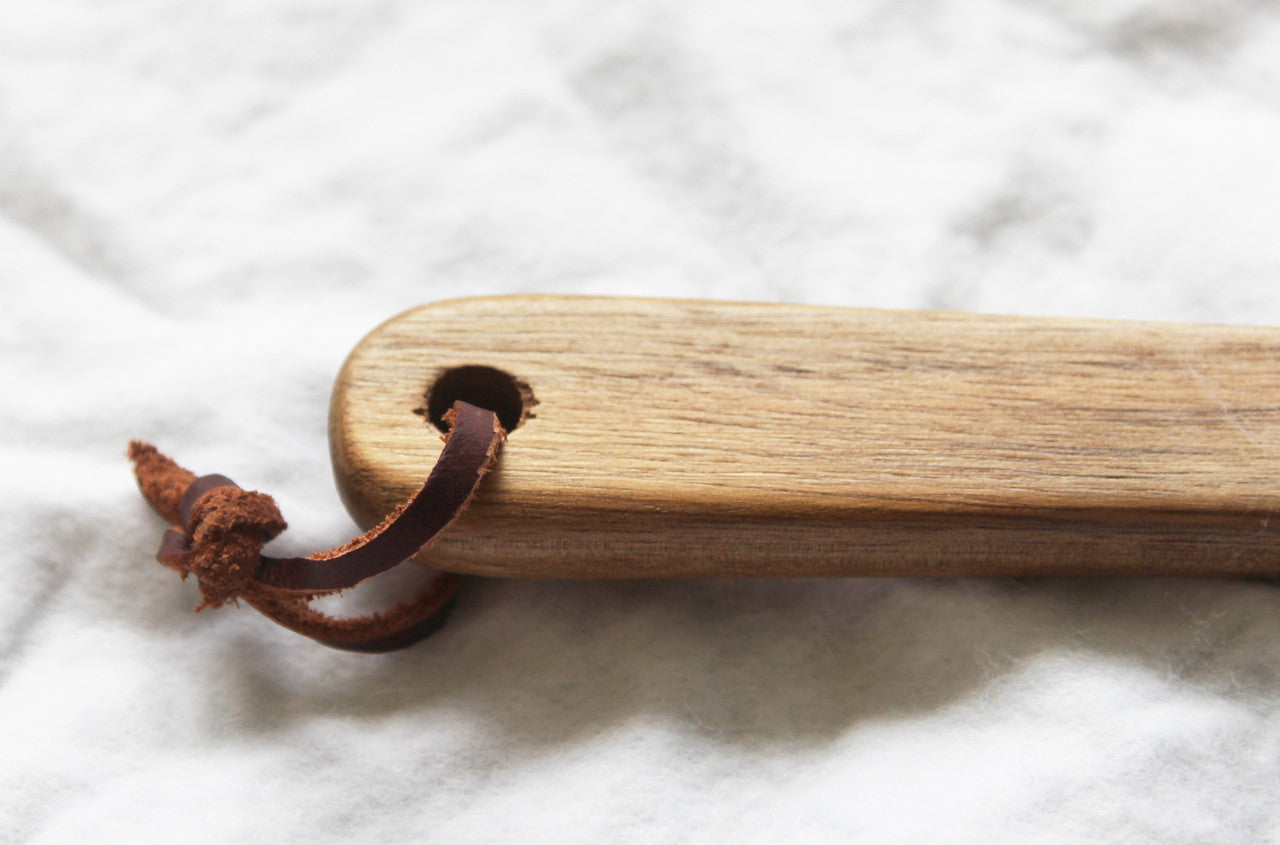 A set of 10 wooden spoon bottle openers with leather hang straps, showcasing their natural wood finish and practical design.