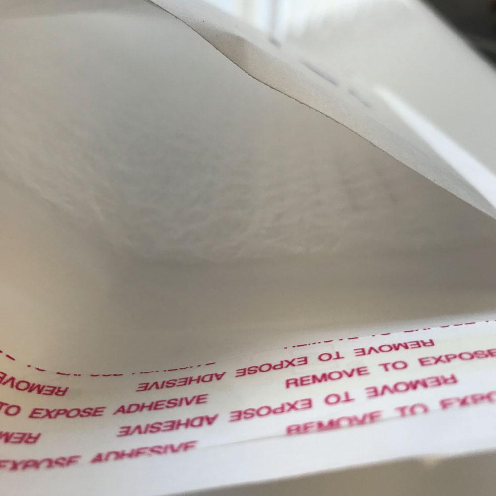 A pack of 100 Tempest 265x380mm white bubble mailers, showcasing their padded design and tamper-evident seal.